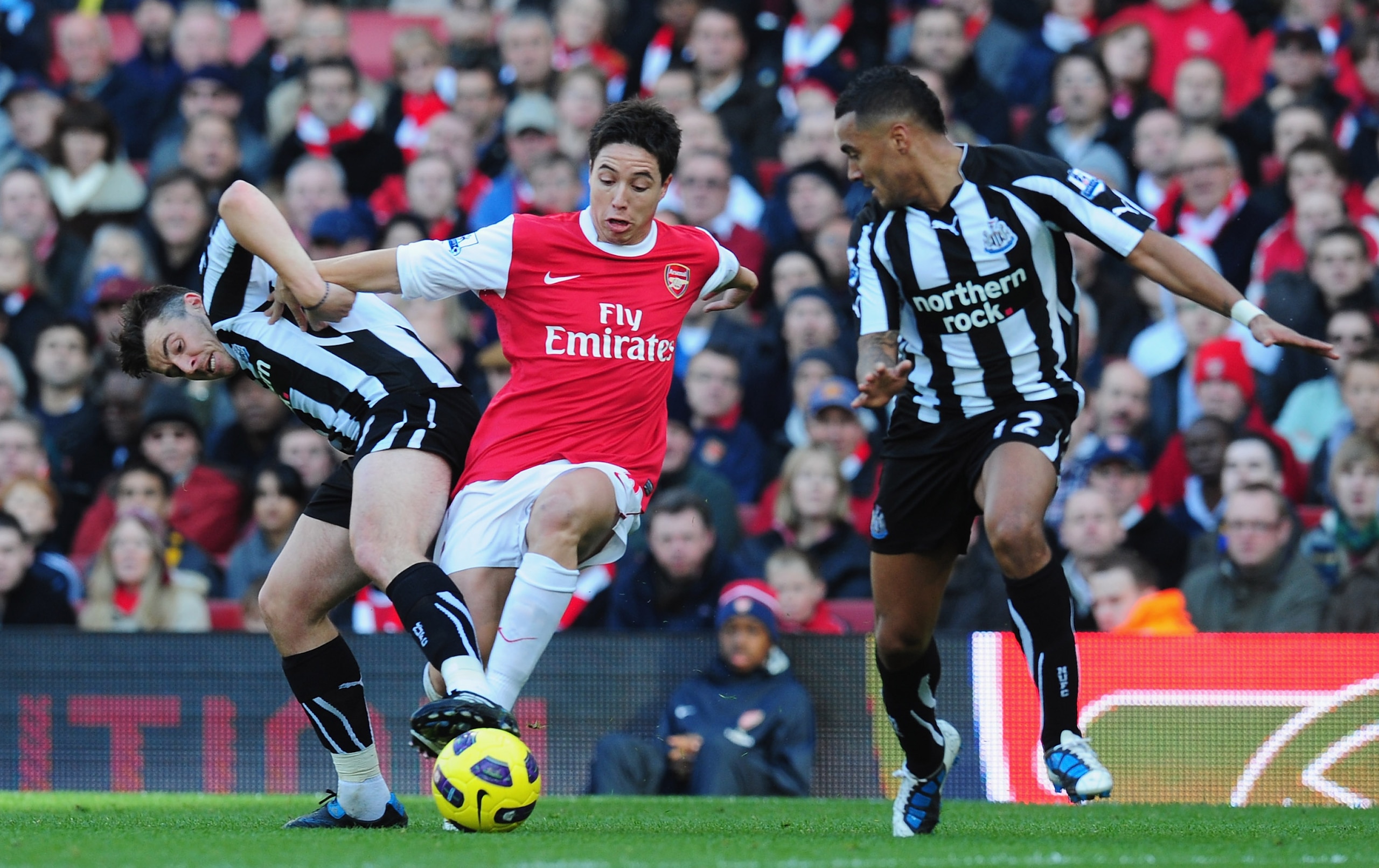 LONDON, ENGLAND - NOVEMBER 07:  Samir Nasri of Arsenal is challenged by Joey Barton and Danny Simpson of Newcastle during the Barclays Premier League match between Arsenal and Newcastle United at the Emirates Stadium on November 7, 2010 in London, England