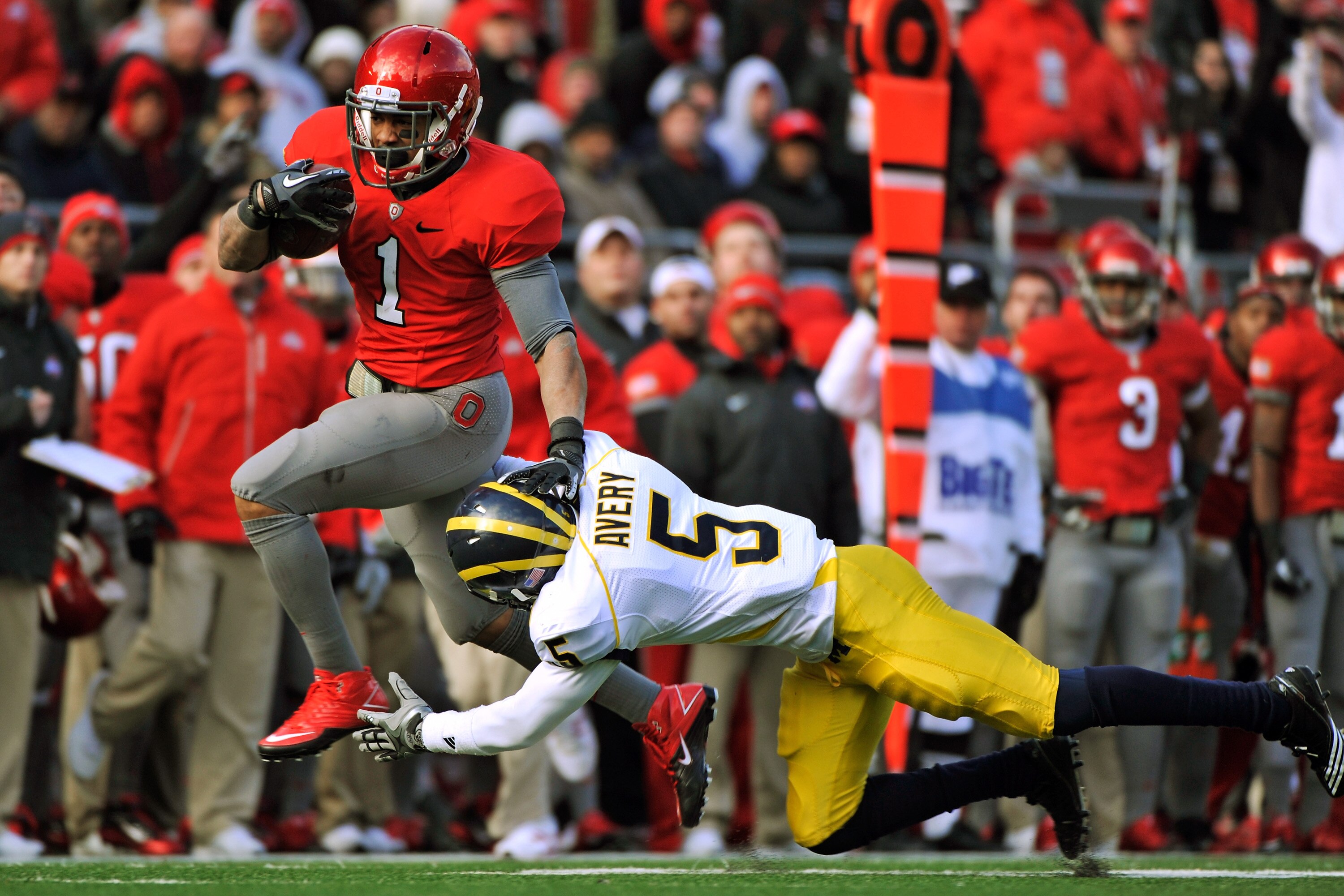 COLUMBUS, OH - NOVEMBER 27:  Dan Herron #1 of the Ohio State Buckeyes eludes the tackle attempt of Courtney Avery #5 of the Michigan Wolverines on his way to a 32-yard touchdown run in the third quarter at Ohio Stadium on November 27, 2010 in Columbus, Oh