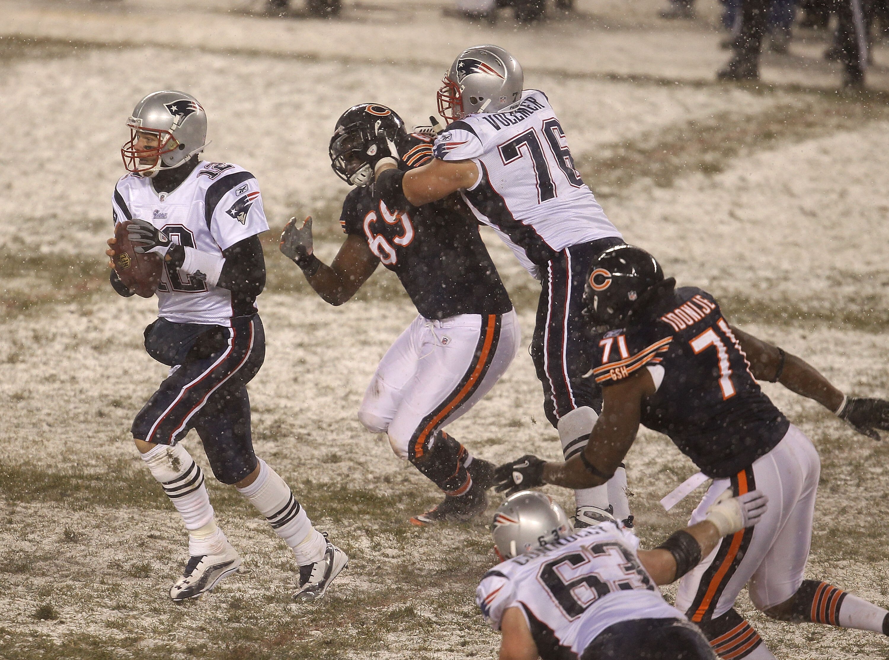 CHICAGO, IL - DECEMBER 12: Tom Brady #12 of the New England Patriots looks for a receiver as teammate Sebastian Vollmer #76 blocks Henry Melton #69 of the Chicago Bears and Israel Idonije #71 rushes at Soldier Field on December 12, 2010 in Chicago, Illino