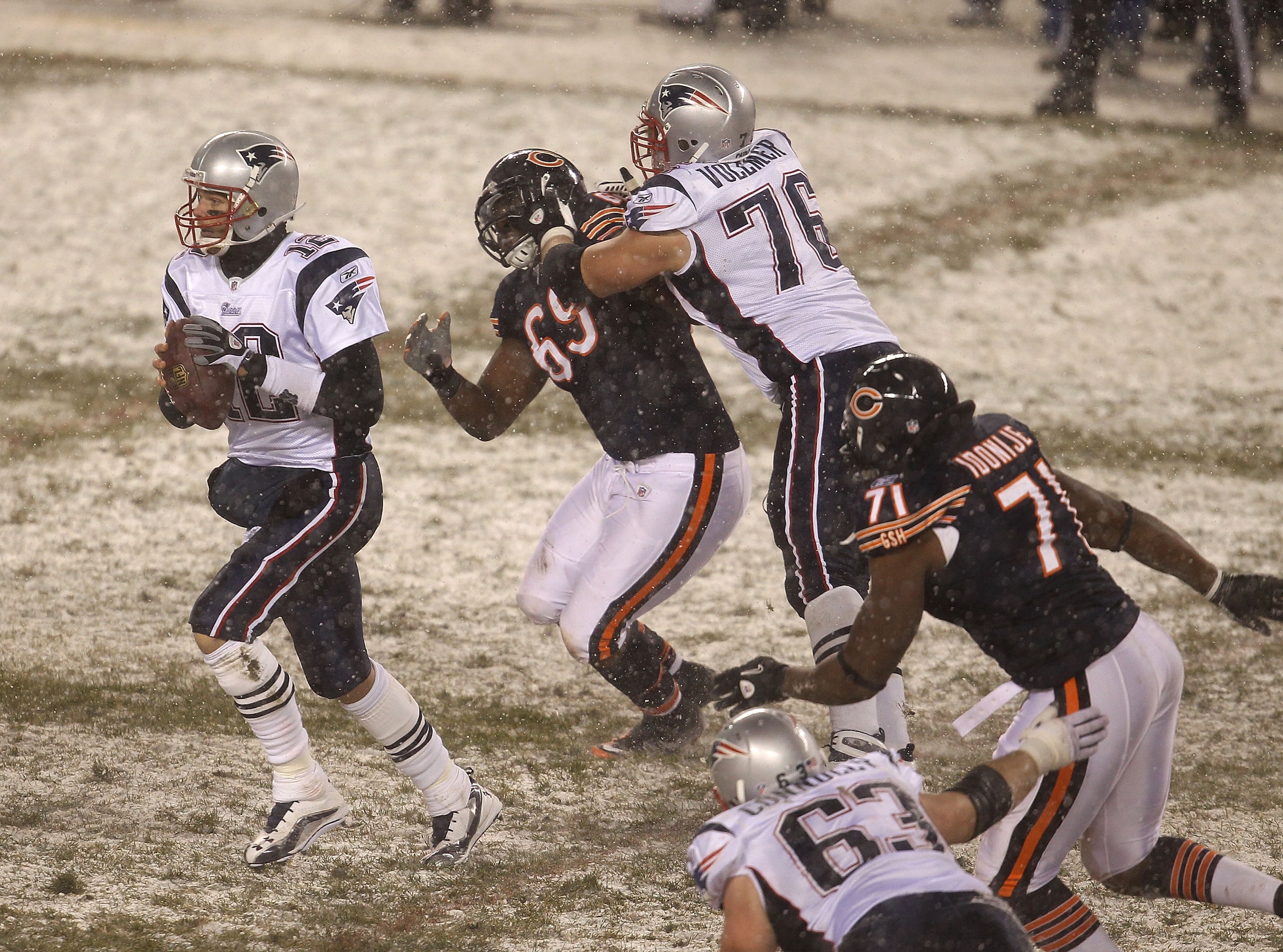 CHICAGO, IL - DECEMBER 12: Tom Brady #12 of the New England Patriots looks for a receiver as teammate Sebastian Vollmer #76 blocks Henry Melton #69 of the Chicago Bears and Israel Idonije #71 rushes at Soldier Field on December 12, 2010 in Chicago, Illino CHICAGO, IL - DECEMBER 12: Tom Brady #12 of the New England Patriots looks for a receiver as teammate Sebastian Vollmer #76 blocks Henry Melton #69 of the Chicago Bears and Israel Idonije #71 rushes at Soldier Field on December 12, 2010 in Chicago, Illino
