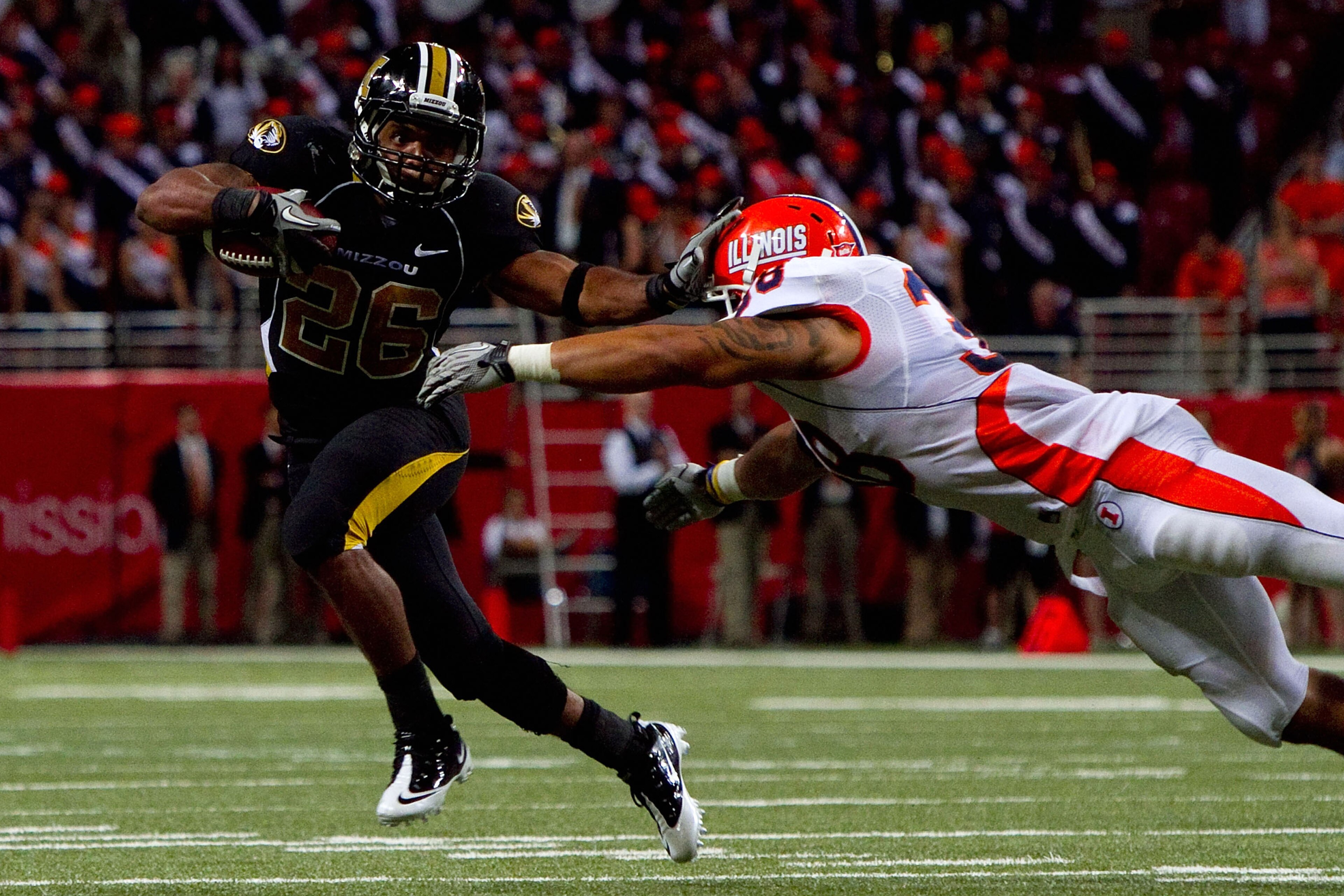 ST. LOUIS - SEPTEMBER 4: De'Vion Moore #26 of the University of Missouri Tigers looks to get past Ian Thomas #38 of the University of Illinois Fighting Illini during the State Farm Arch Rivalry game on September 4, 2010 at the Edward Jones Dome in St. Lou