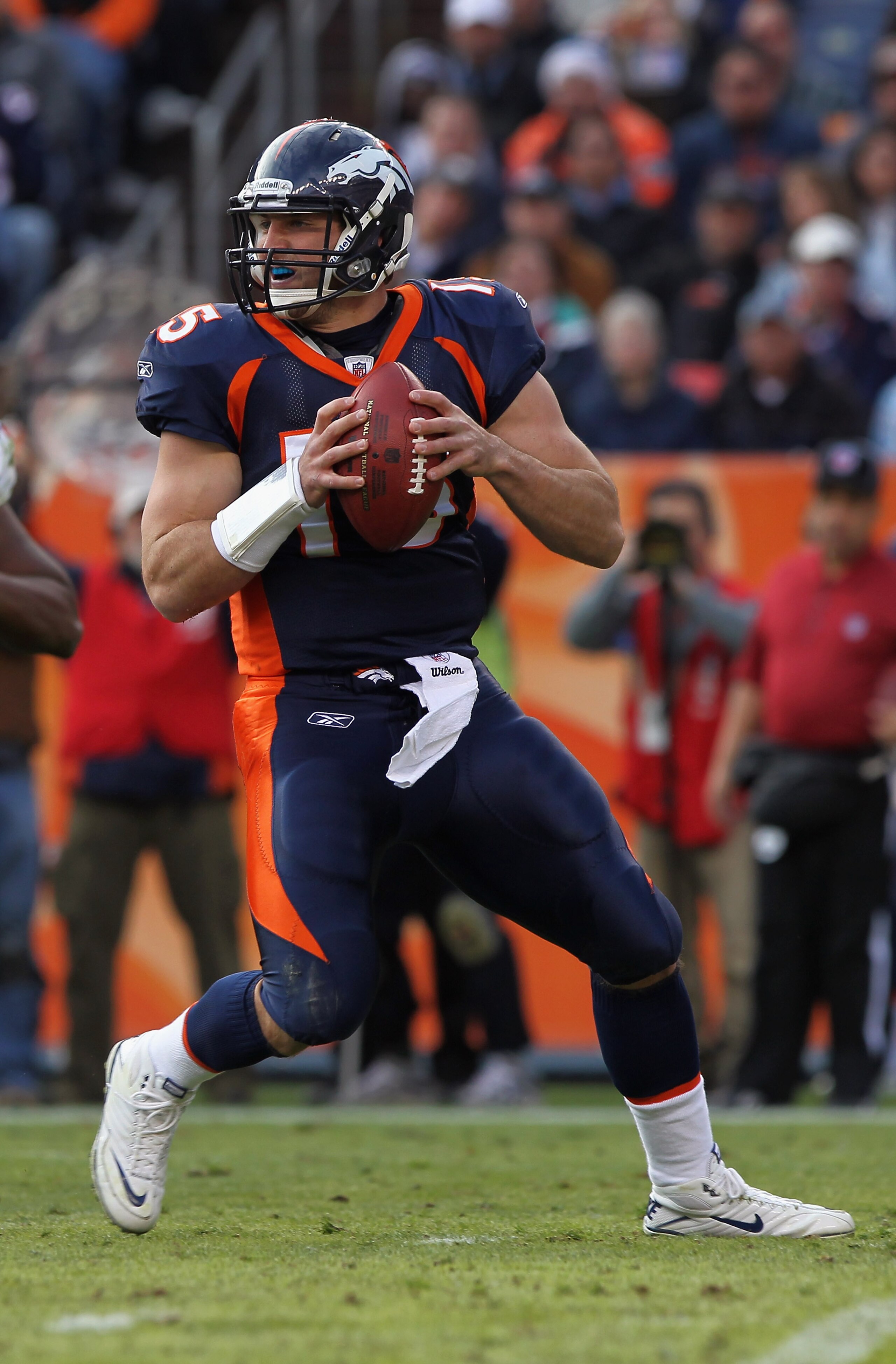 DENVER - DECEMBER 26: Quarterback Tim Tebow #15 of the Denver Broncos rolls out and looks to deliver a pass against the Houston Texas at INVESCO Field at Mile High on December 26, 2010 in Denver, Colorado. The Broncos defeated the Texans 24-23. (Photo b DENVER - DECEMBER 26: Quarterback Tim Tebow #15 of the Denver Broncos rolls out and looks to deliver a pass against the Houston Texas at INVESCO Field at Mile High on December 26, 2010 in Denver, Colorado. The Broncos defeated the Texans 24-23. (Photo b