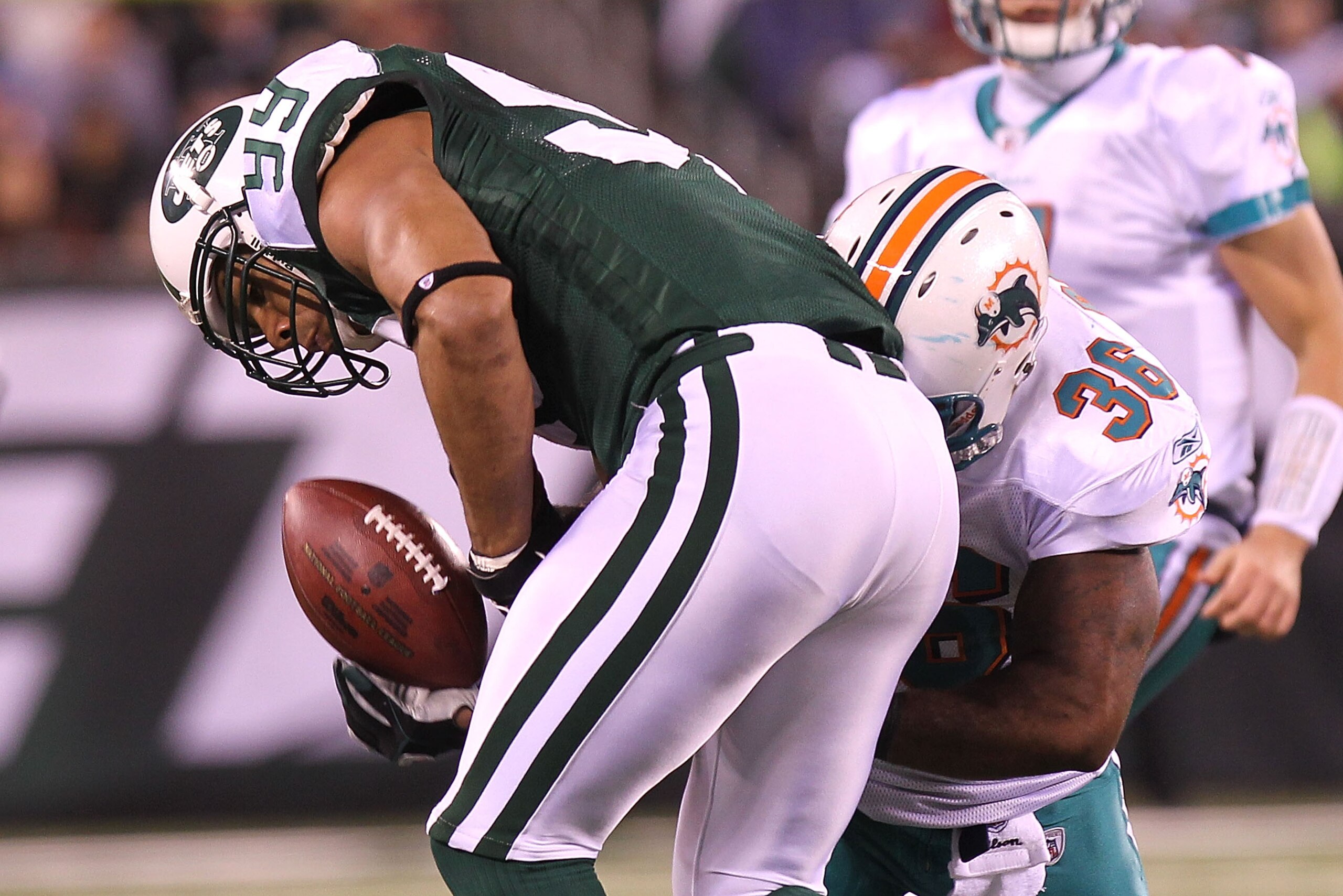 EAST RUTHERFORD, NJ - DECEMBER 12: Jason Taylor #99 of the New York Jets has a possible interception broken up by Lousaka Polite #36 of the Miami Dolphins at New Meadowlands Stadium on December 12, 2010 in East Rutherford, New Jersey.  (Photo by Nick Laha