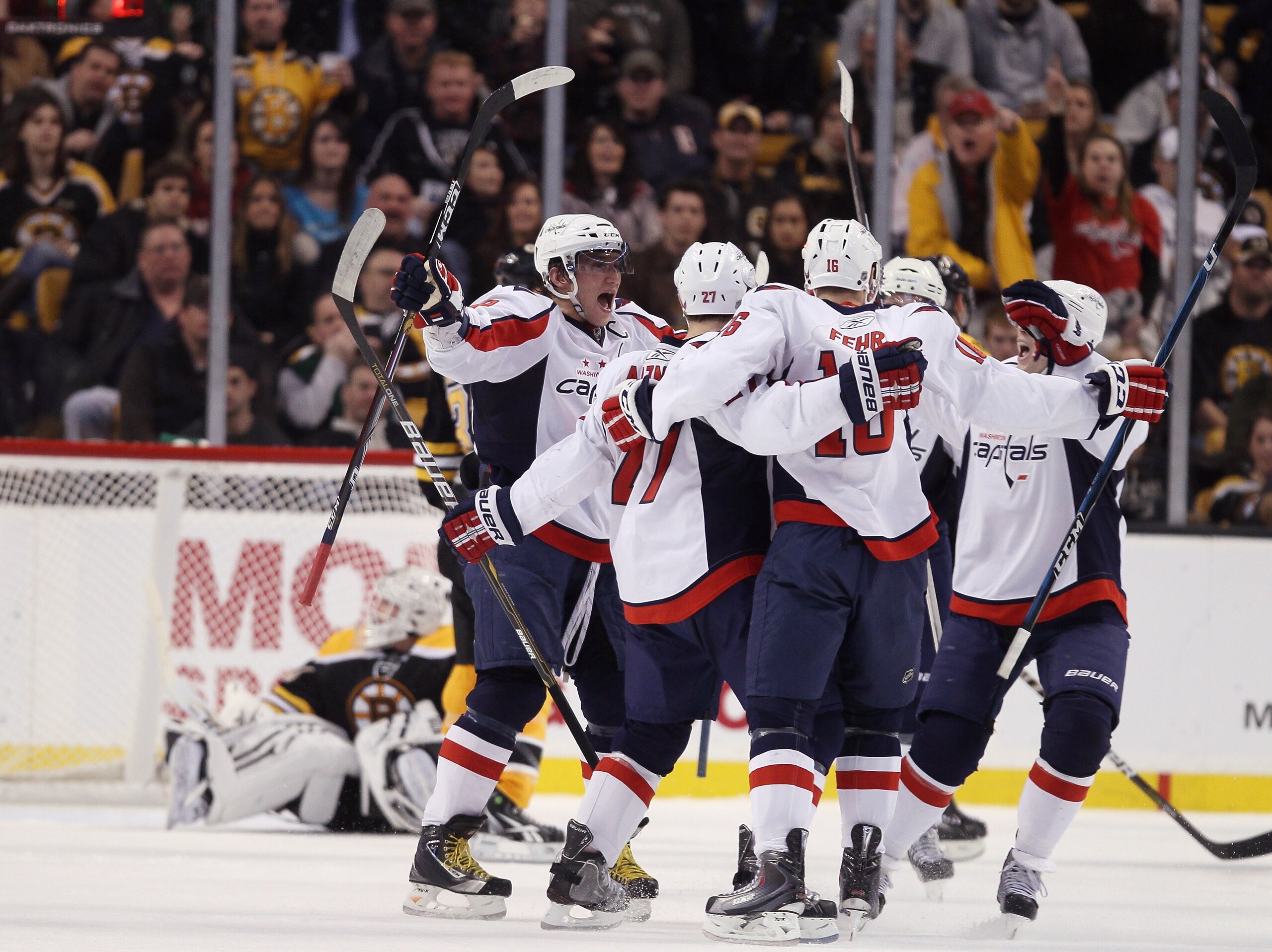 BOSTON, MA - DECEMBER 18:  Alex Ovechkin #8 of the Washington Capitals celebrates with teammates Karl Alzner #27 and Matt Bradley #10 after Alzner scored a goal in the third period as Tim Thomas #30 of the Boston Bruins sits in his net on December 18, 201