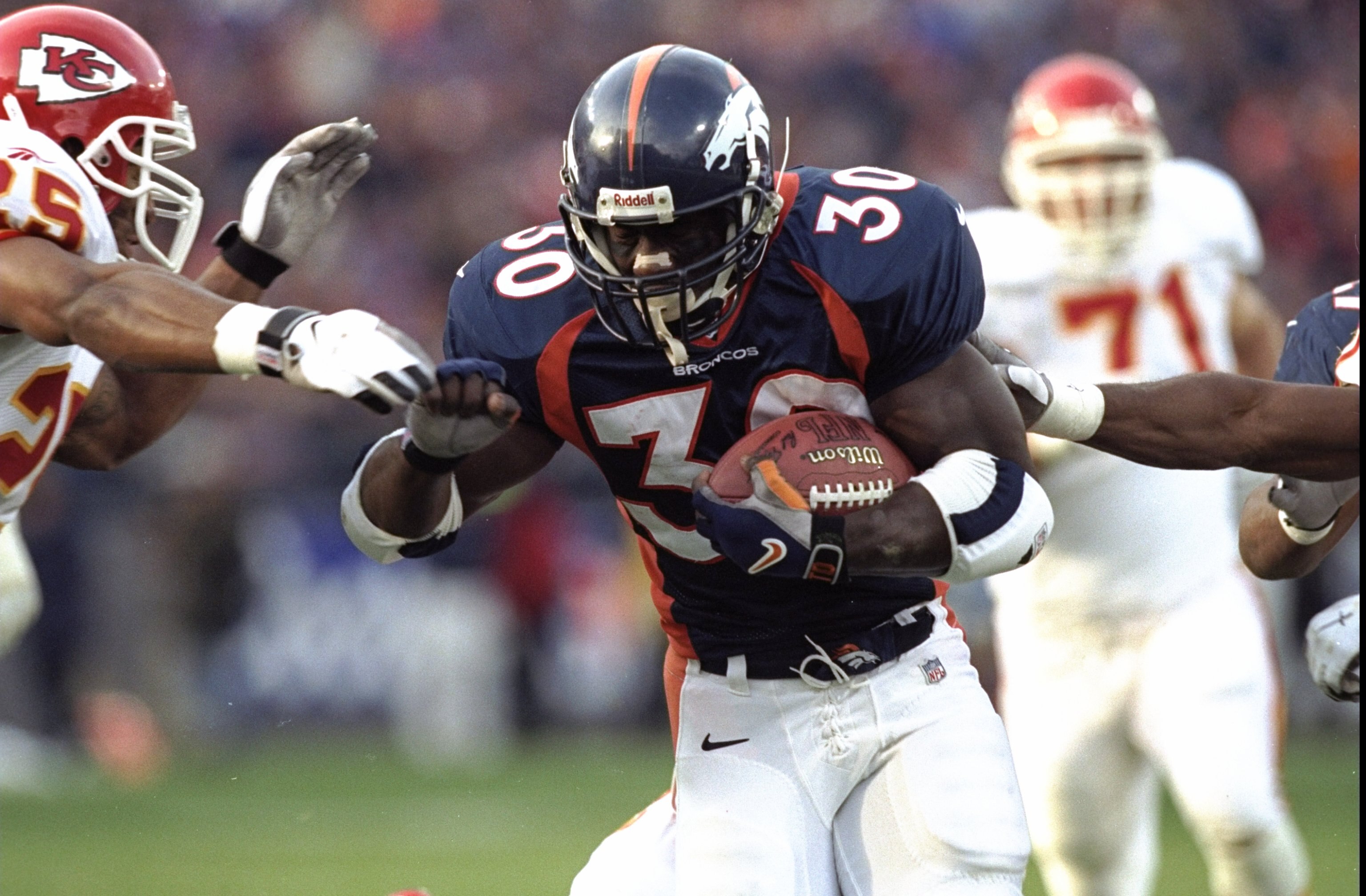 6 Dec 1998: Running back Terrell Davis #30 of the Denver Broncos in action against safety Reggie Tongue #25 of the Kansas City Chiefs during the game at Mile High Stadium in Denver, Colorado. The Broncos defeated the Chiefs 35-31.