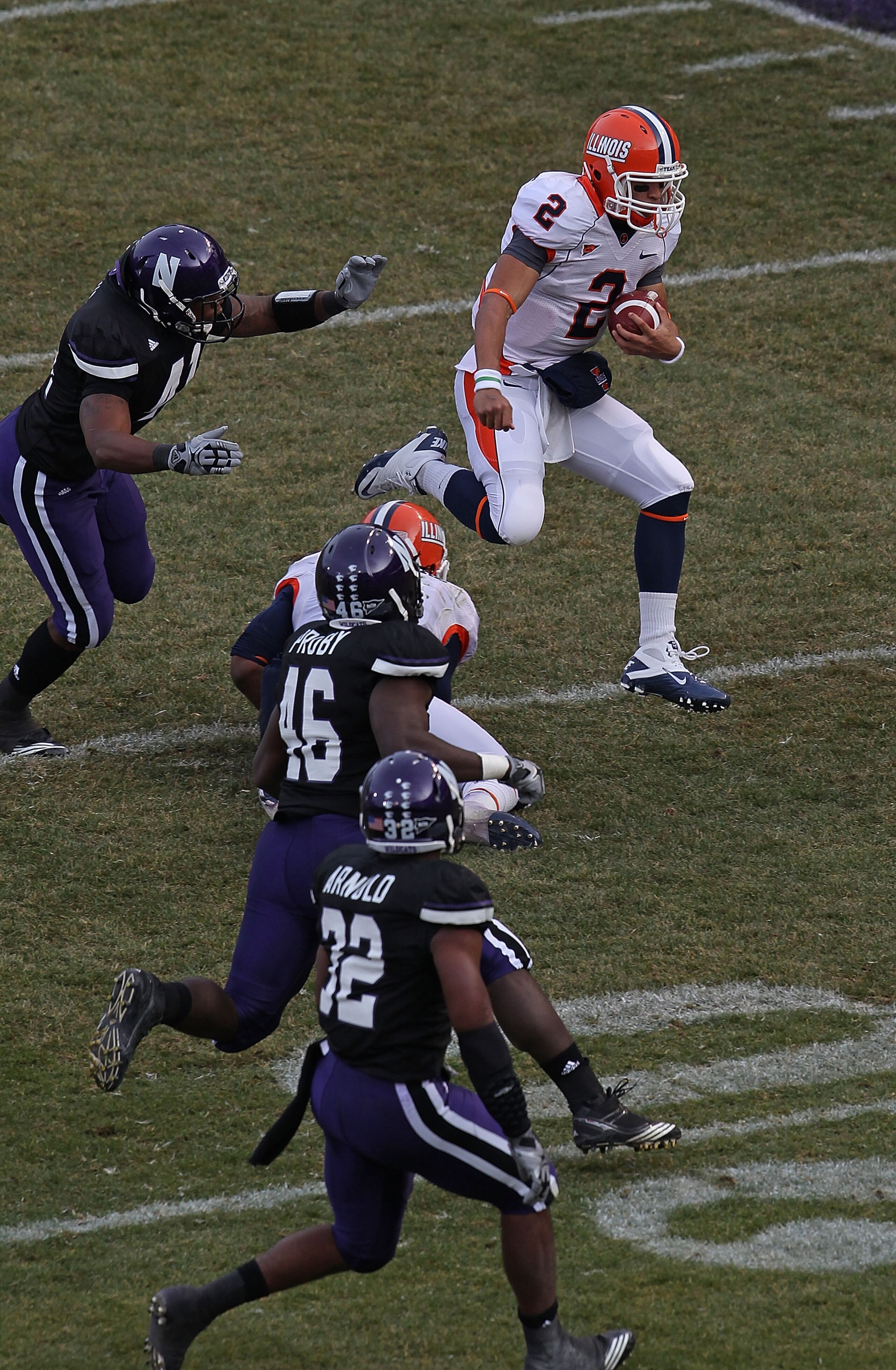 CHICAGO - NOVEMBER 20: Nathan Scheelhaase #2 of the Illinois Fighting Illini runs for a first down pursued by Nate Williams #44, Damien Proby #46 and David Arnold #32 of the Northwestern Wildcats during a game played at Wrigley Field on November 20, 2010