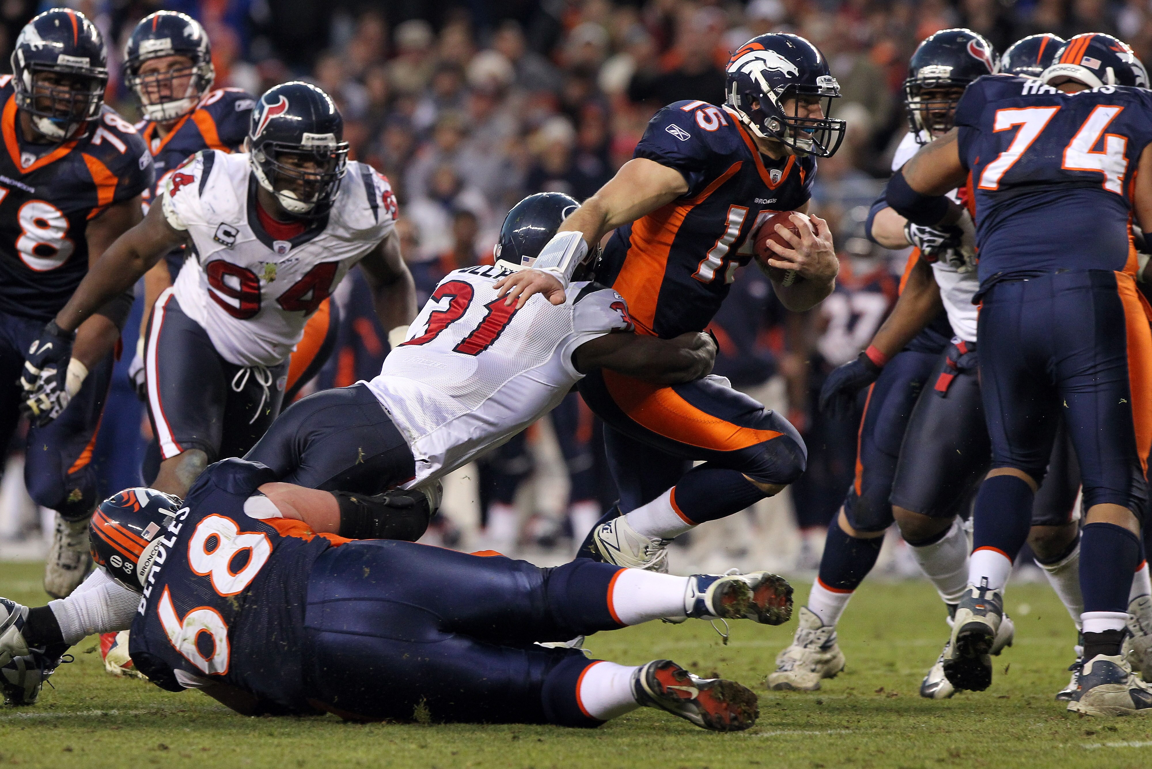 DENVER - DECEMBER 26:  Quarterback Tim Tebow #15 of the Denver Broncos rushes with the ball and is tackled by strong safety Bernard Pollard #31 of the Houston Texas at INVESCO Field at Mile High on December 26, 2010 in Denver, Colorado. The Broncos defeat