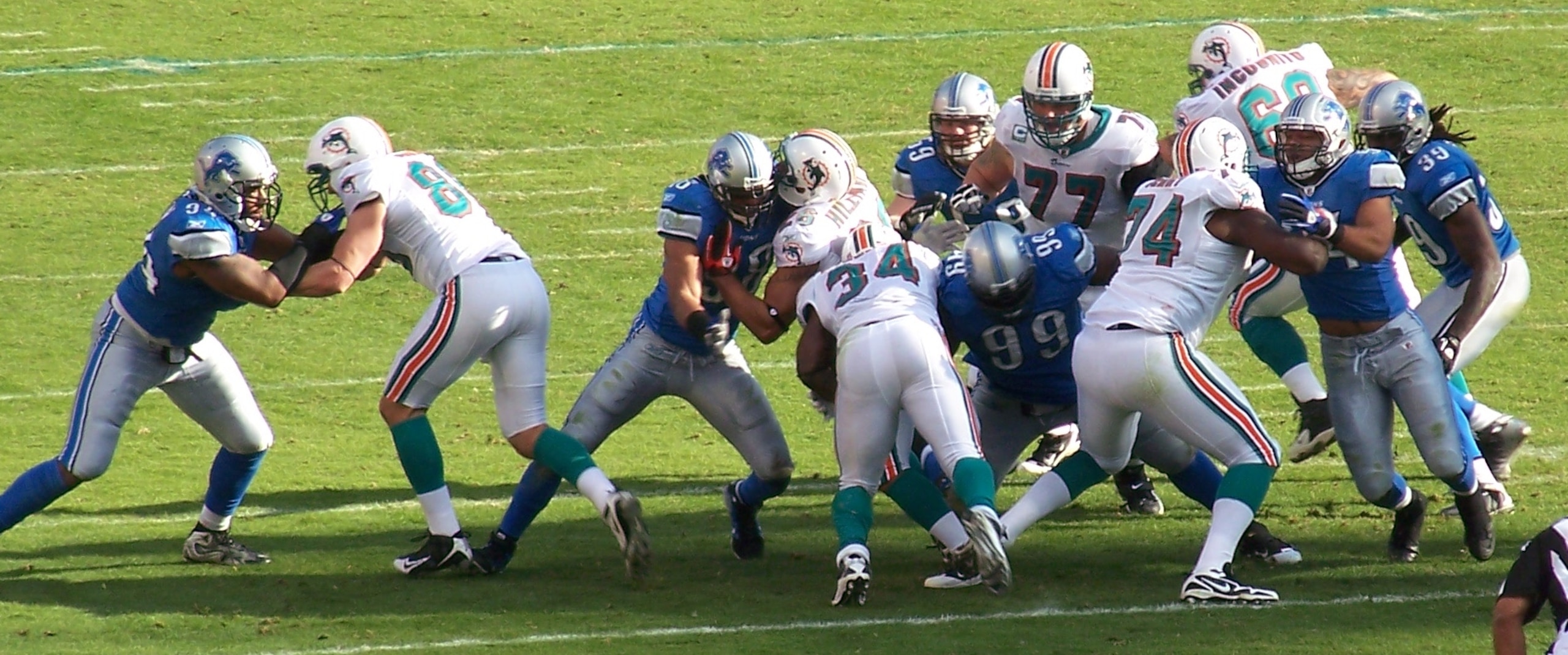 Corey Williams and Bobby Carpenter converge on Dolphins running back Ricky Williams