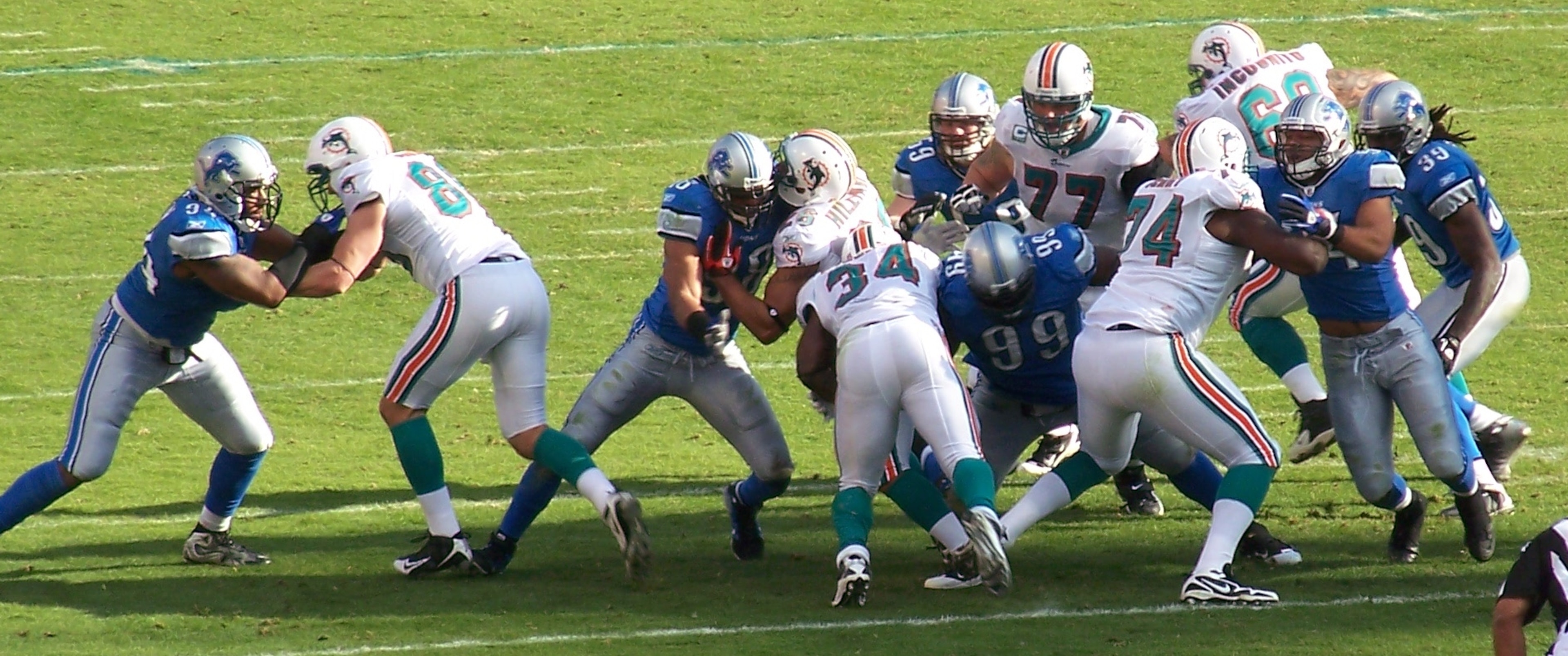 Corey Williams and Bobby Carpenter converge on Dolphins running back Ricky Williams