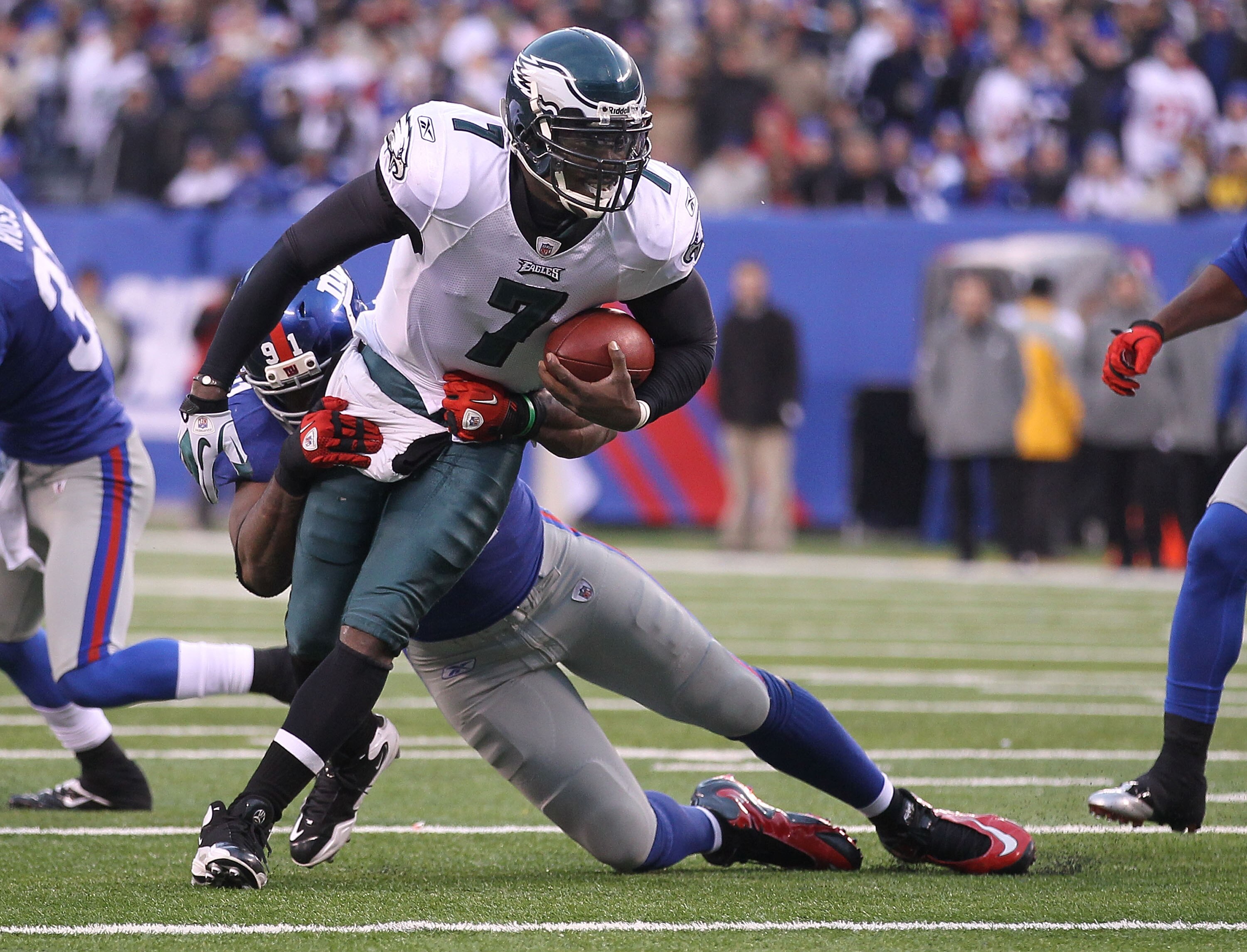 EAST RUTHERFORD, NJ - DECEMBER 19:  Justin Tuck #91 of the New York Giants tackles Michael Vick #7 of the Philadelphia Eagles during their game on December 19, 2010 at The New Meadowlands Stadium in East Rutherford, New Jersey.  (Photo by Al Bello/Getty I