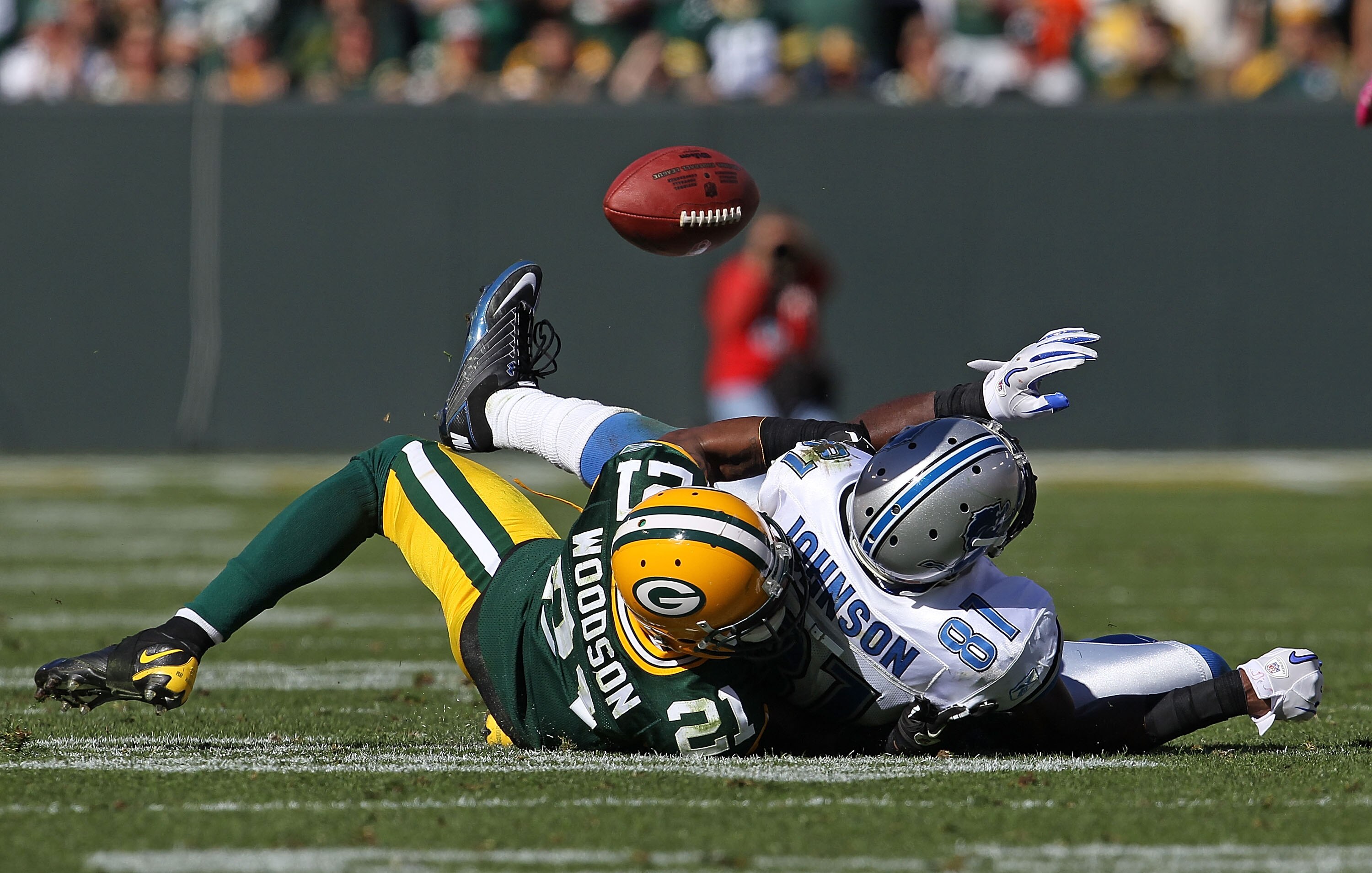 GREEN BAY, WI - OCTOBER 03: Charles Woodson #21 of the Green Bay Packers breaks up a pass intended for Calvin Johnson #81 of the Detroit Lions by taking him to the ground at Lambeau Field on October 3, 2010 in Green Bay, Wisconsin. The Packers defeated th