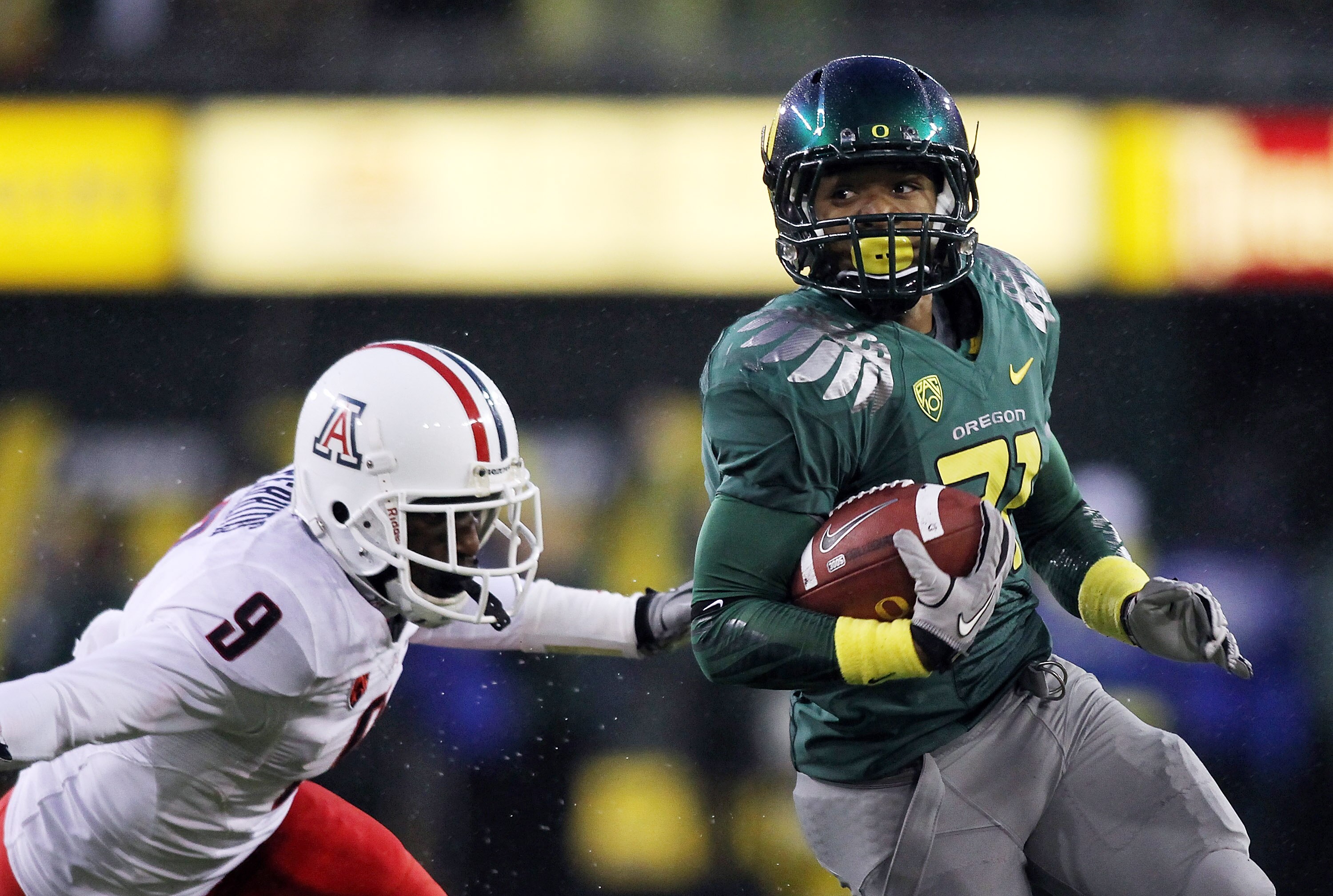 EUGENE, OR - NOVEMBER 26:  LaMichael James #21 of the Oregon Ducks runs past Joseph Perkins #9 of the Arizona Wildcats on November 26, 2010 at the Autzen Stadium in Eugene, Oregon.  (Photo by Jonathan Ferrey/Getty Images)
