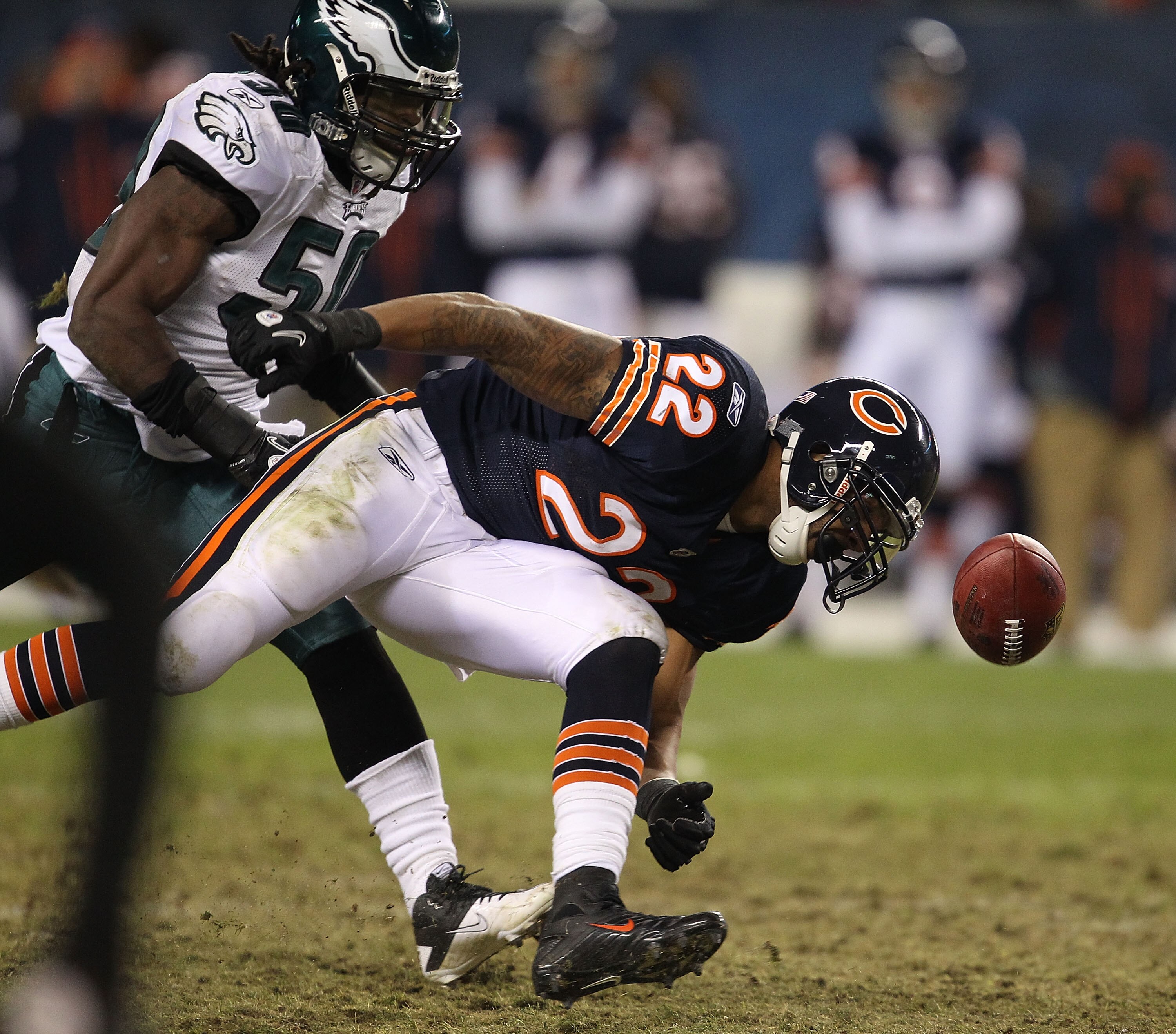CHICAGO - NOVEMBER 28: Matt Forte #22 of the Chicago Bears can't hold onto the football after being pushed by Ernie Sims #50 of the Philadelphia Eagles at Soldier Field on November 28, 2010 in Chicago, Illinois. The Bears defeated the Eagles 31-26. (Photo