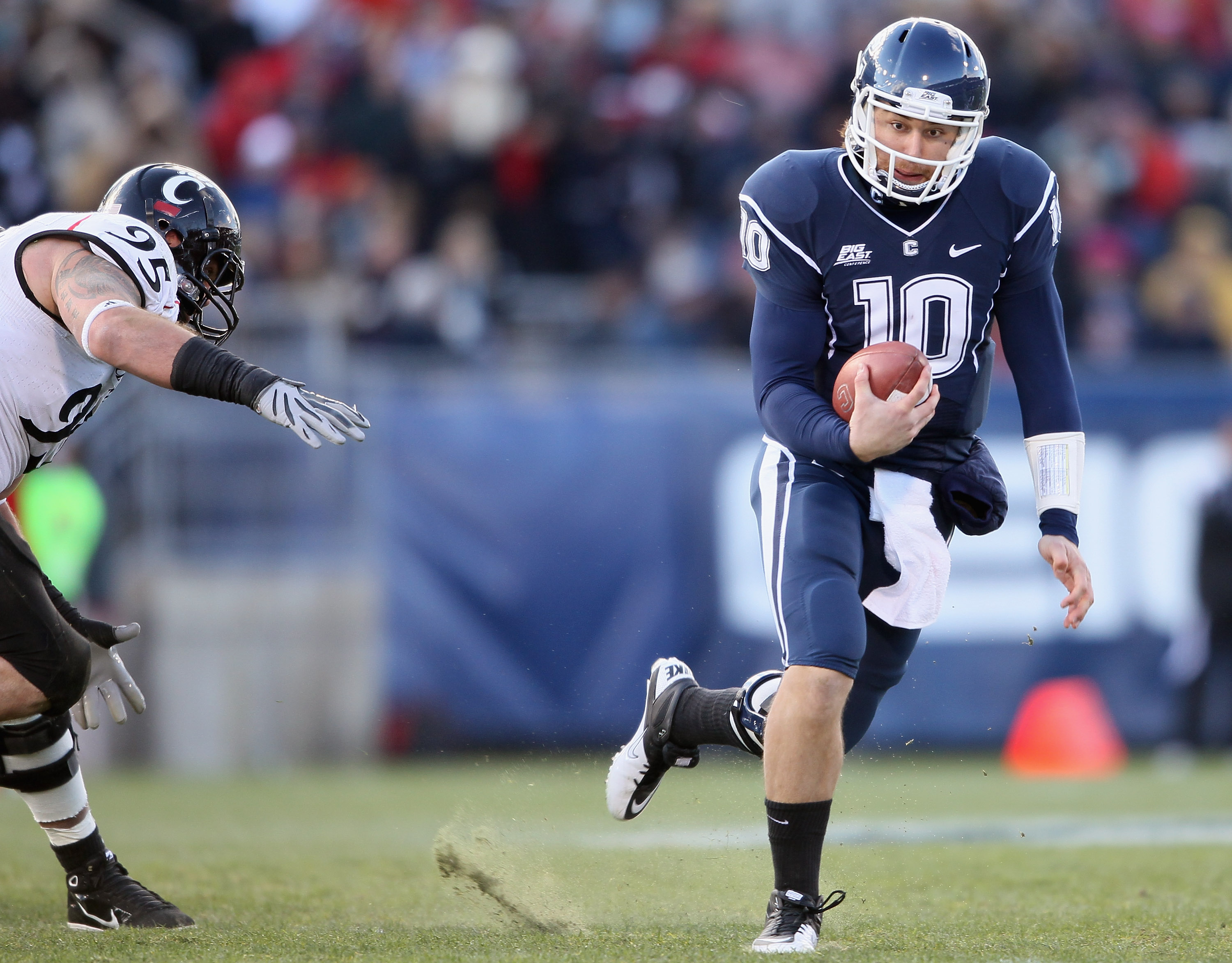 EAST HARTFORD, CT - NOVEMBER 27:  Zach Frazer #10 of the Connecticut Huskies carries the ball as Derek Wolfe #95 of the Cincinnati Bearcats defends on November 27, 2010 at Rentschler Field in East Hartford, Connecticut.  (Photo by Elsa/Getty Images)