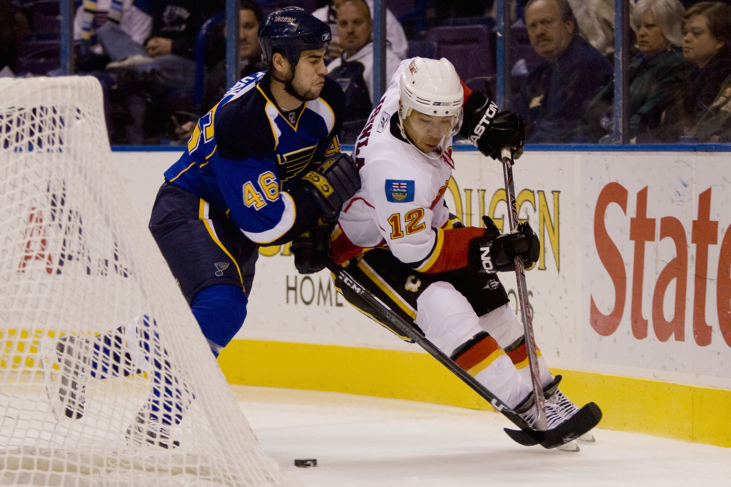 ST. LOUIS, MO - DECEMBER 5: Jarome Iginla #12 of the Calgary Flames looks to control the puck against Roman Polak #46 of the St. Louis Blues at the Scottrade Center on December 5, 2008 in St. Louis, Missouri.  (Dilip Vishwanat/Getty Images)