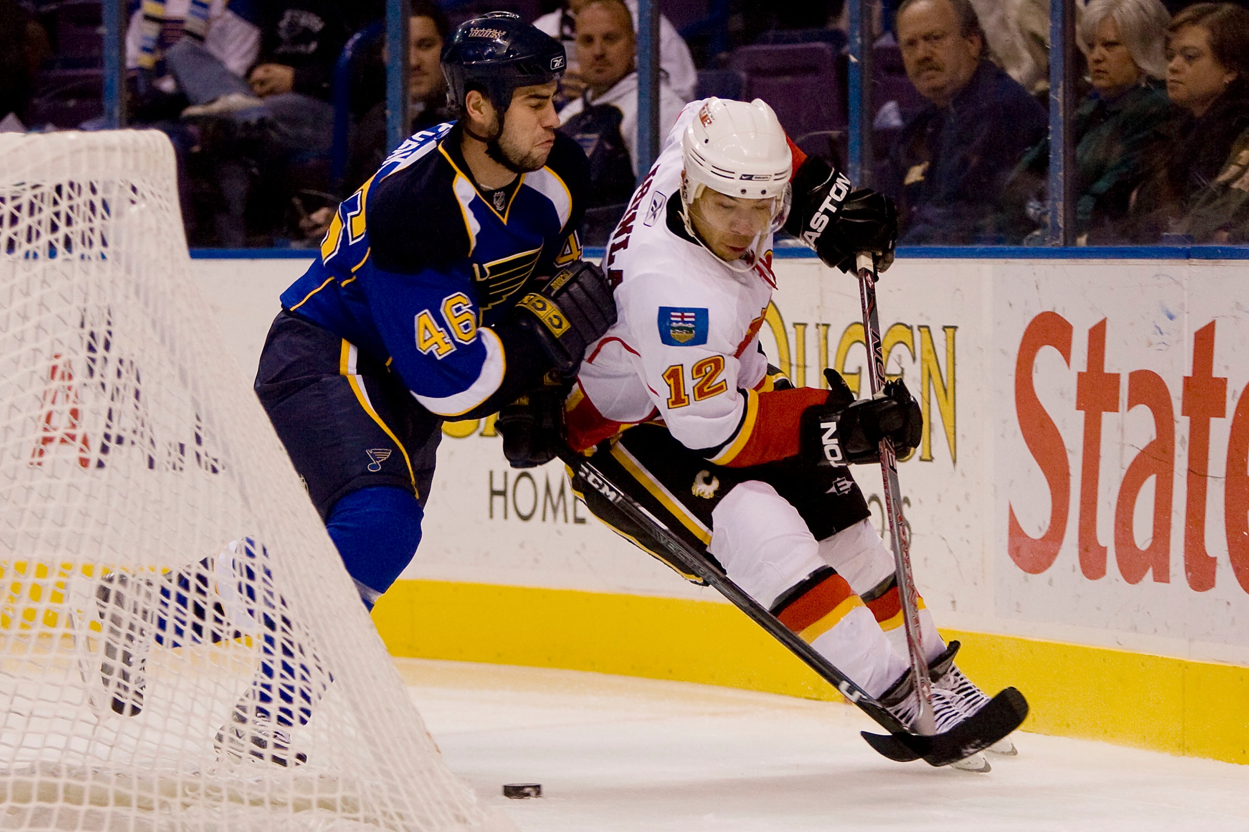 ST. LOUIS, MO - DECEMBER 5: Jarome Iginla #12 of the Calgary Flames looks to control the puck against Roman Polak #46 of the St. Louis Blues at the Scottrade Center on December 5, 2008 in St. Louis, Missouri.  (Dilip Vishwanat/Getty Images)