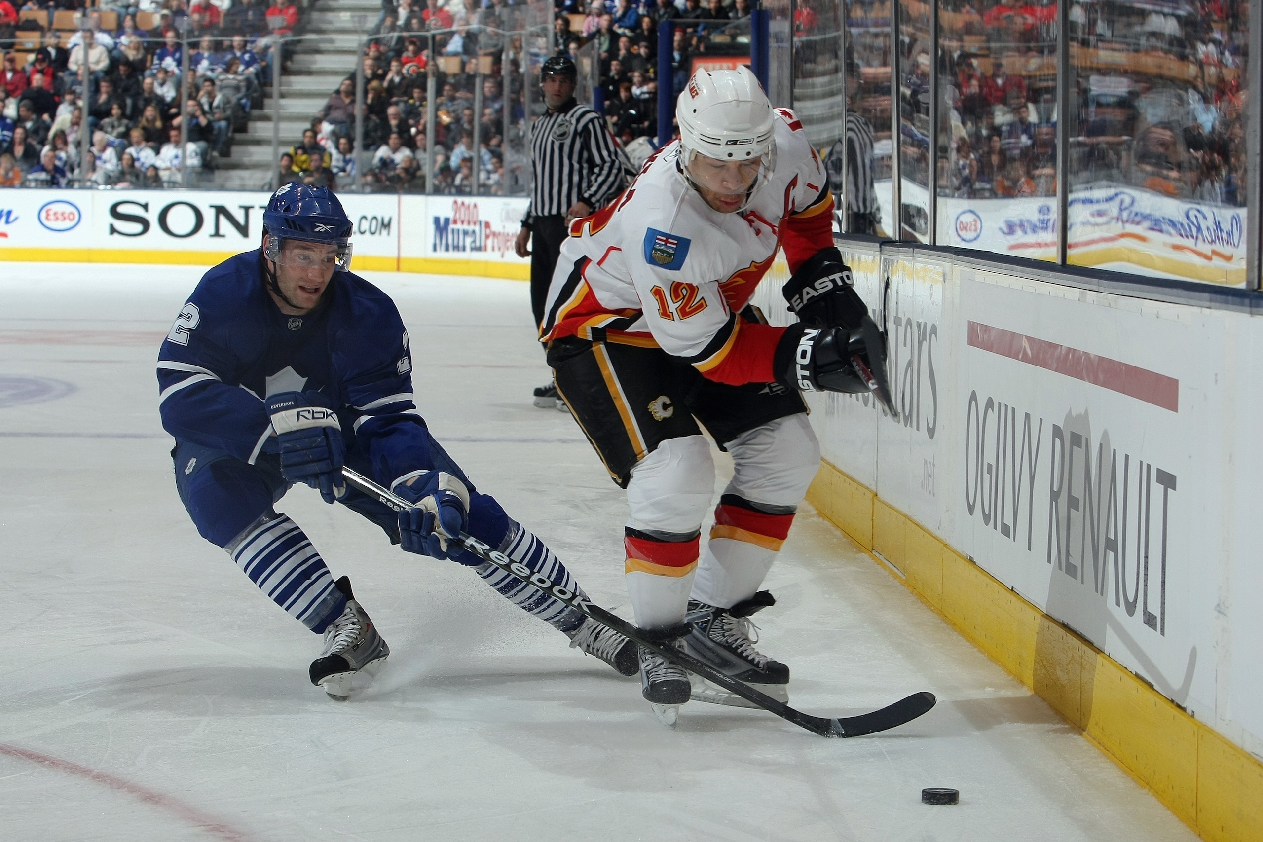 TORONTO - MARCH 14:  Boyd Devereaux #22 of the Toronto Maple Leafs skates to the puck against Jarome Iginla #12 of the Calgary Flames during the game at Air Canada Centre on March 14, 2009 in Toronto, Ontario, Canada. (Photo by Dave Sandford/Getty Images)