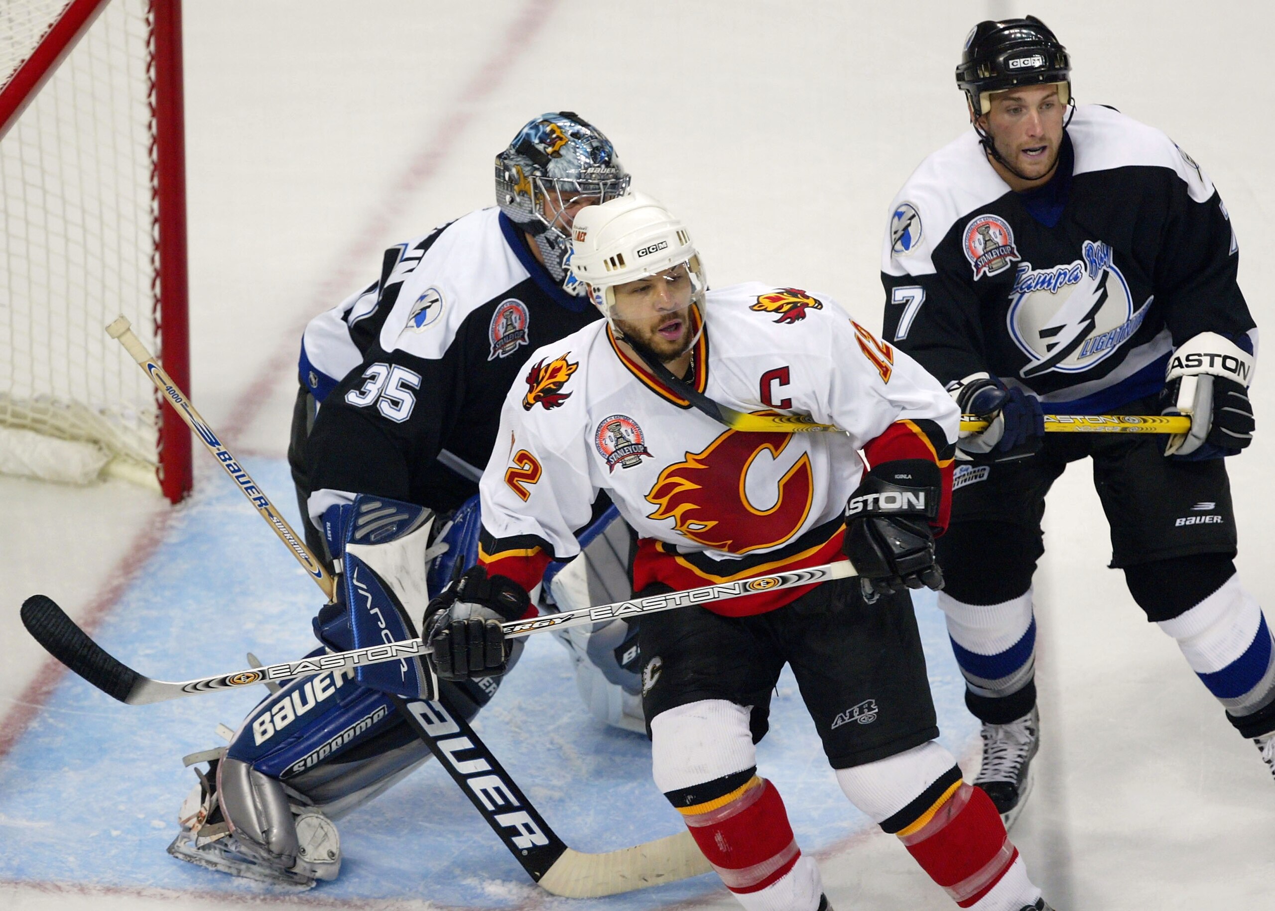 TAMPA, FL - JUNE 7:   Jarome Iginla #12 of the Calgary Flames is covered in the crease by Ben Clymer and goaltender Nikolai Khabibulin #35 of the Tampa Bay Lightning in game seven of the NHL Stanley Cup Finals on June 7, 2004 at the St. Pete Times Forum i