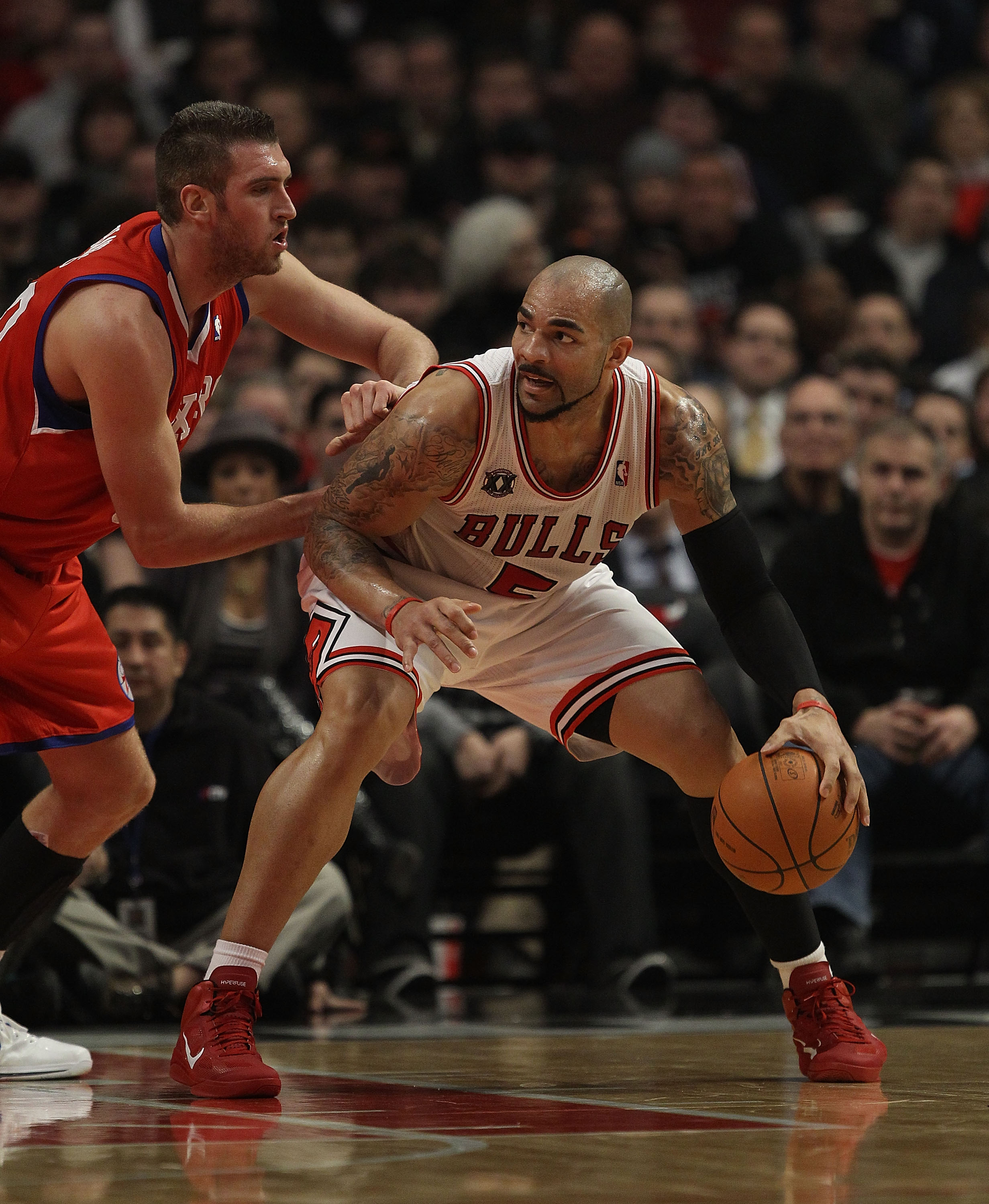 CHICAGO, IL - DECEMBER 21: Carlos Boozer #5 of the Chicago Bulls moves against Spencer Hawes #00 of the Philadelphia 76ers at the United Center on December 21, 2010 in Chicago, Illinois. The Bulls defeated the 76ers 121-76. NOTE TO USER: User expressly ac