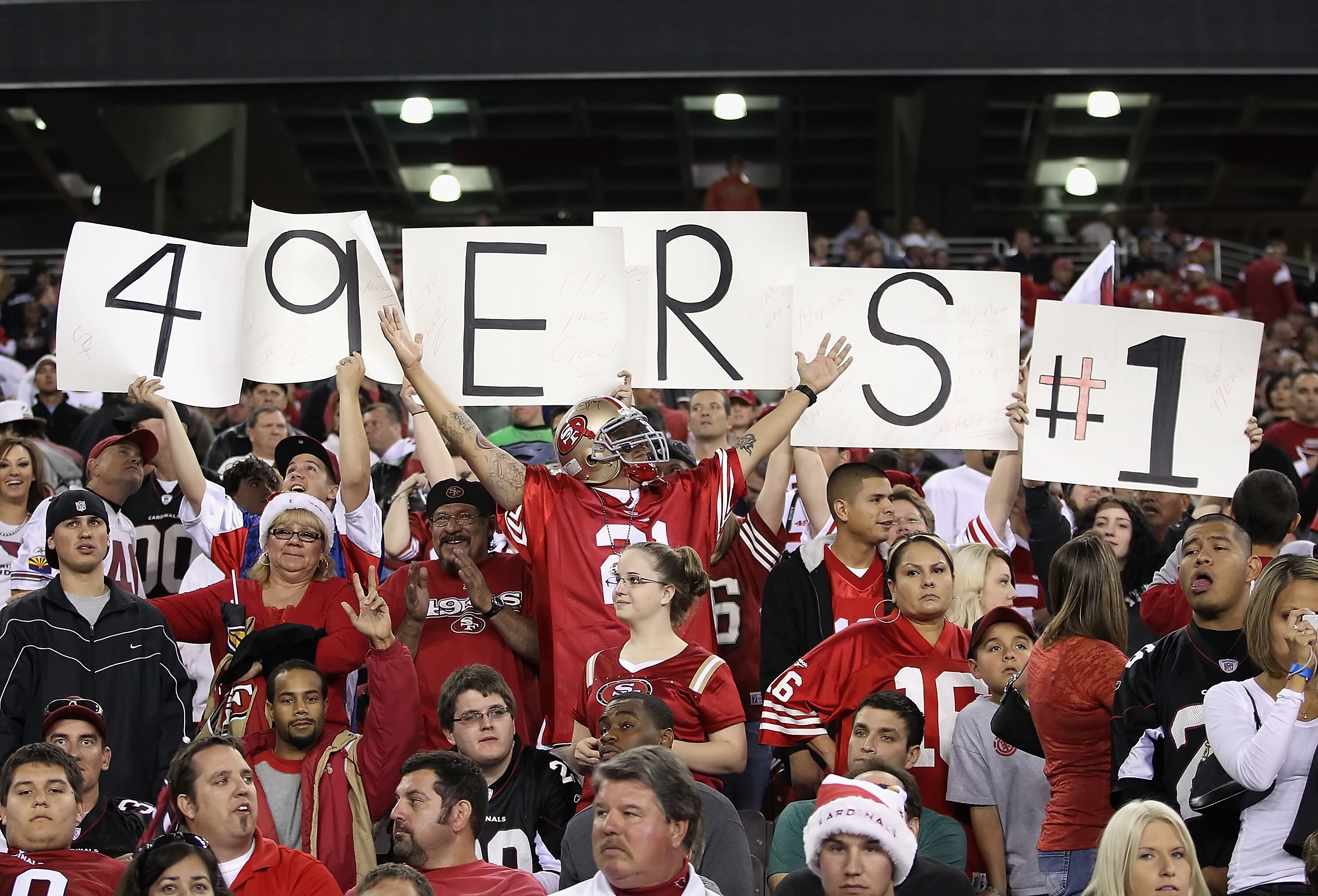 GLENDALE, AZ - NOVEMBER 29:  Fans of the San Francisco 49ers hold up signs and cheer during the NFL game against the Arizona Cardinals at the University of Phoenix Stadium on November 29, 2010 in Glendale, Arizona. The 49ers defeated the Cardinals 27-6.