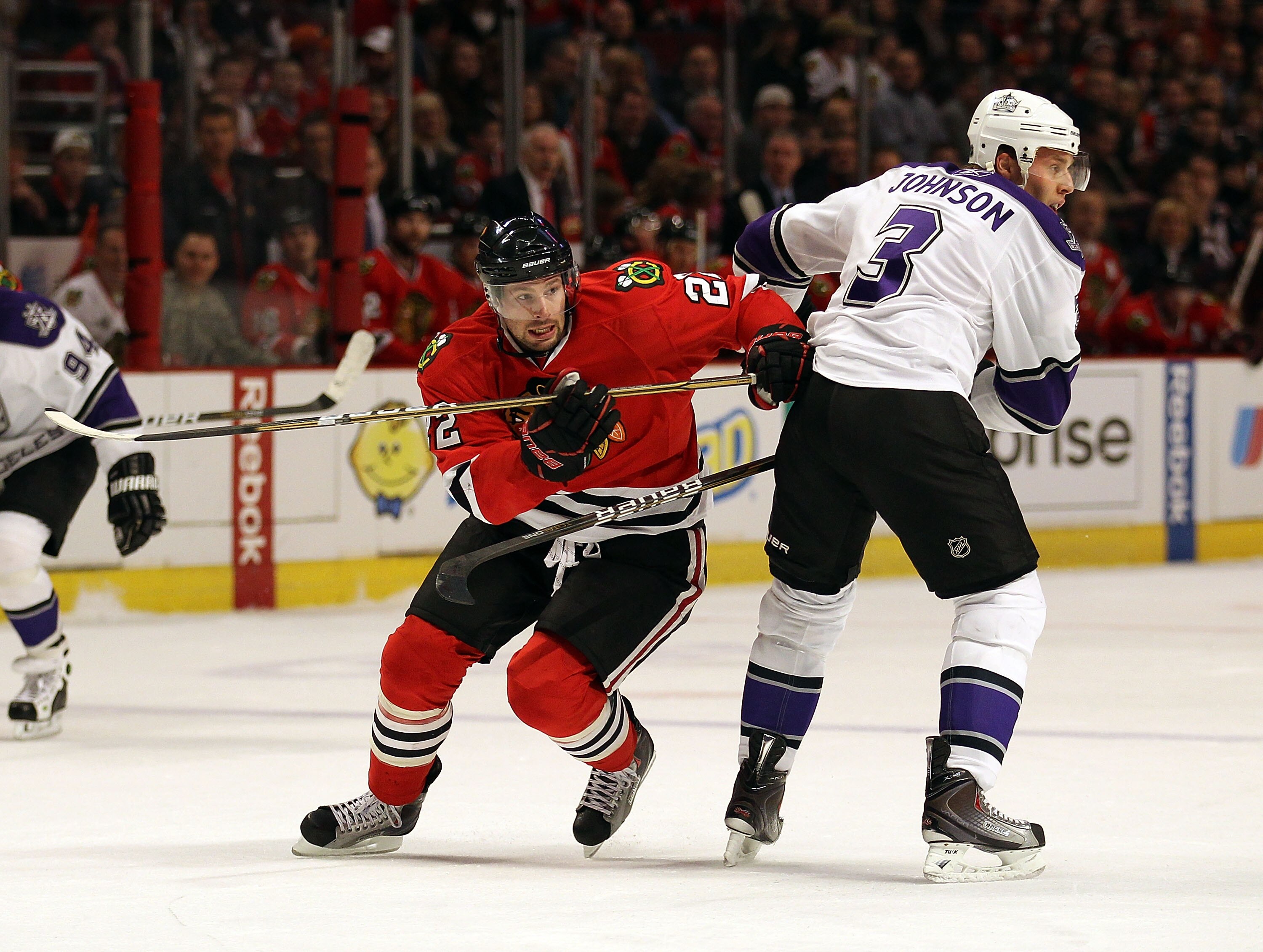 CHICAGO, IL - DECEMBER 19: Troy Brouwer #22 of the Chicago Blackhawks moves to the puck around Jack Johnson #3 of the Los Angeles Kings at the United Center on December 19, 2010 in Chicago, Illinois. The Blackhawks defeated the Kings 3-2.  (Photo by Jonat