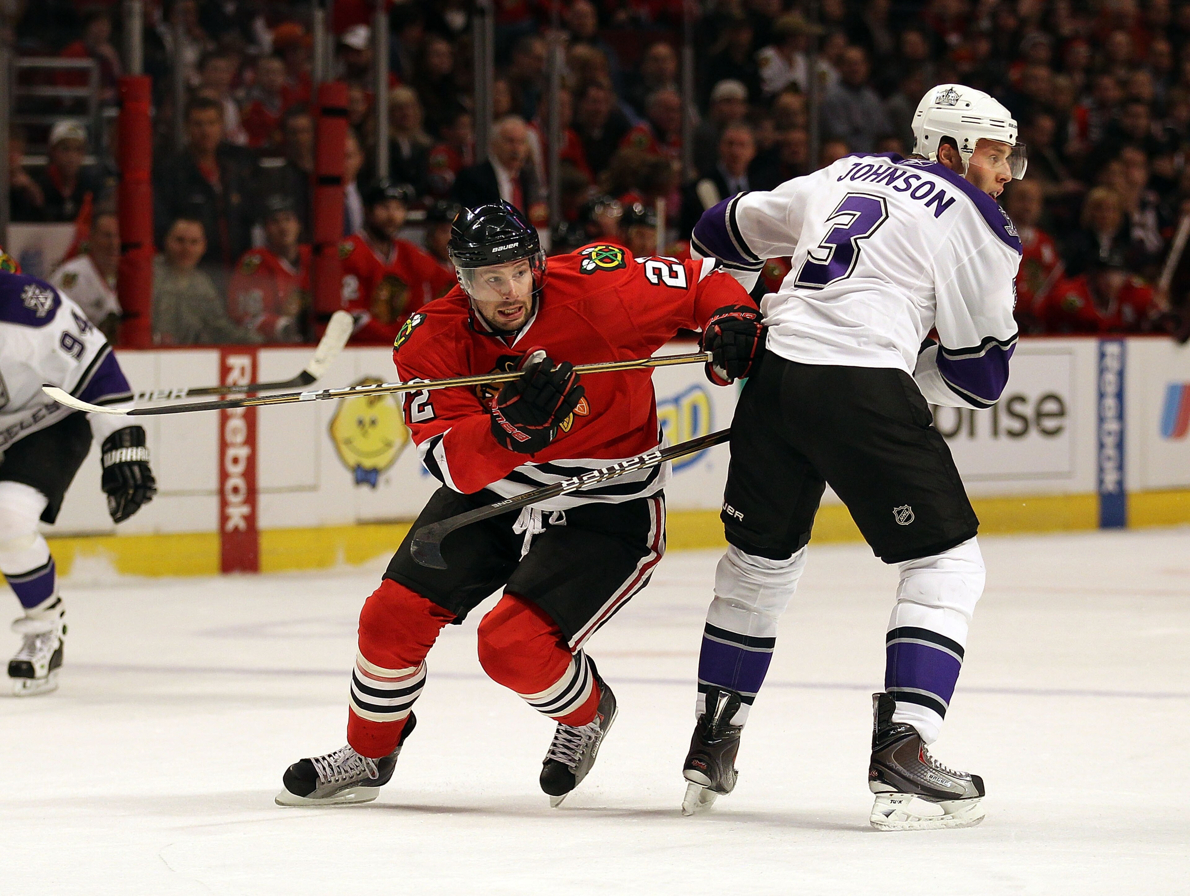 CHICAGO, IL - DECEMBER 19: Troy Brouwer #22 of the Chicago Blackhawks moves to the puck around Jack Johnson #3 of the Los Angeles Kings at the United Center on December 19, 2010 in Chicago, Illinois. The Blackhawks defeated the Kings 3-2.  (Photo by Jonat