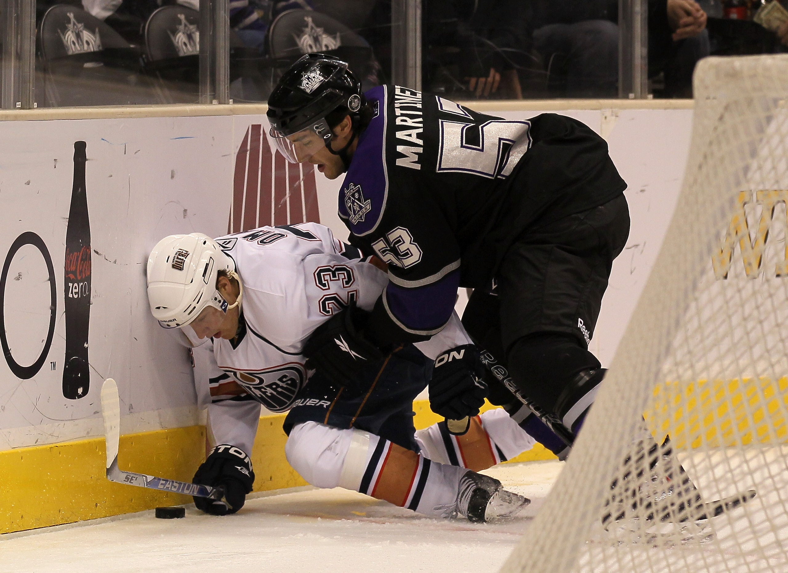 LOS ANGELES, CA - DECEMBER 23: Linus Omark #23 of the Edmonton Oilers tries to cover the puck against Alec Martinez #53 of the Los Angeles Kings at Staples Center on December 23, 2010 in Los Angeles, California. (Photo by Stephen Dunn/Getty Images)