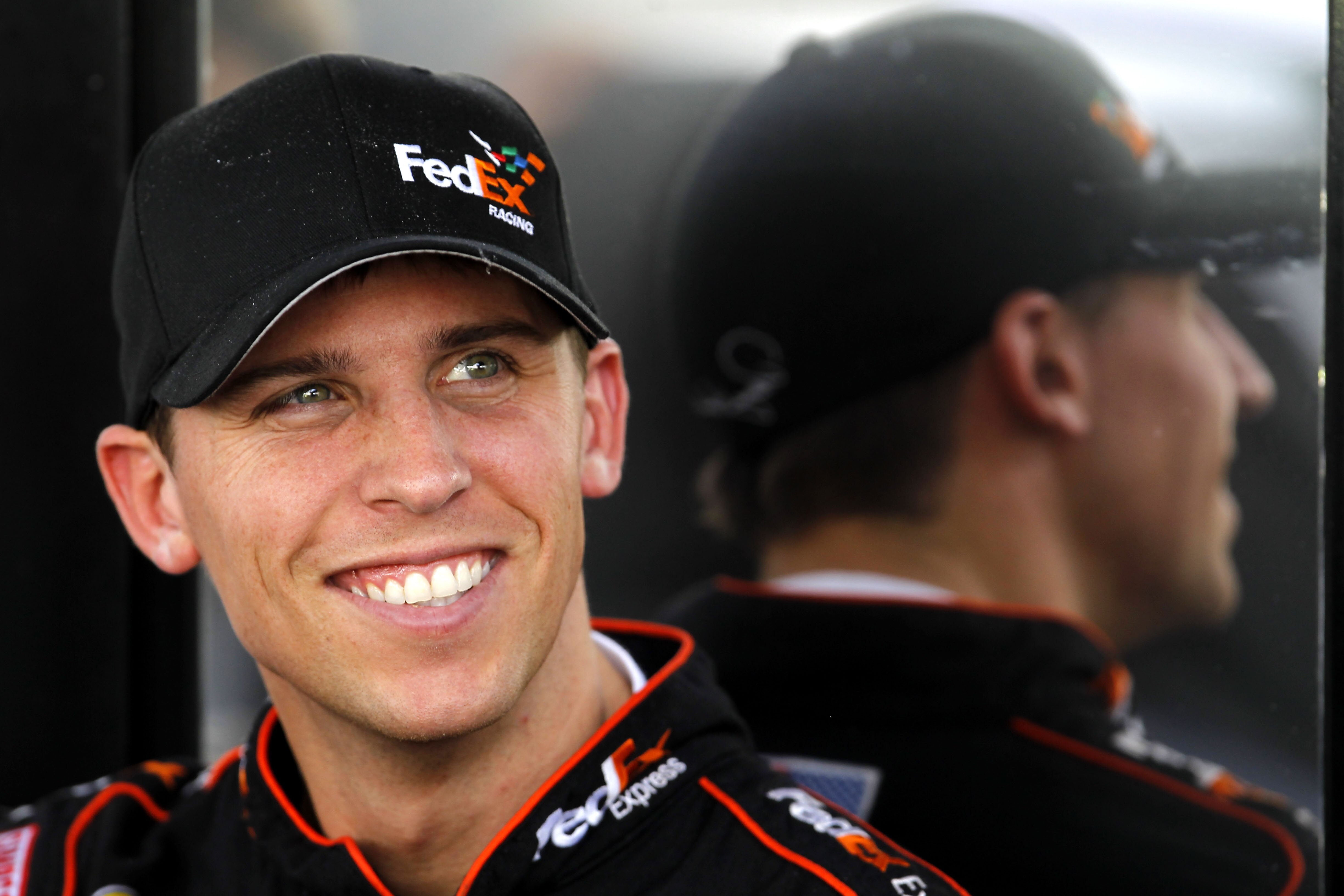 HOMESTEAD, FL - NOVEMBER 19:  Denny Hamlin, driver of the #11 FedEx Toyota, sits by his team hauler in the garage area during practice for the NASCAR Sprint Cup Series Ford 400 at Homestead-Miami Speedway on November 19, 2010 in Homestead, Florida.  (Phot