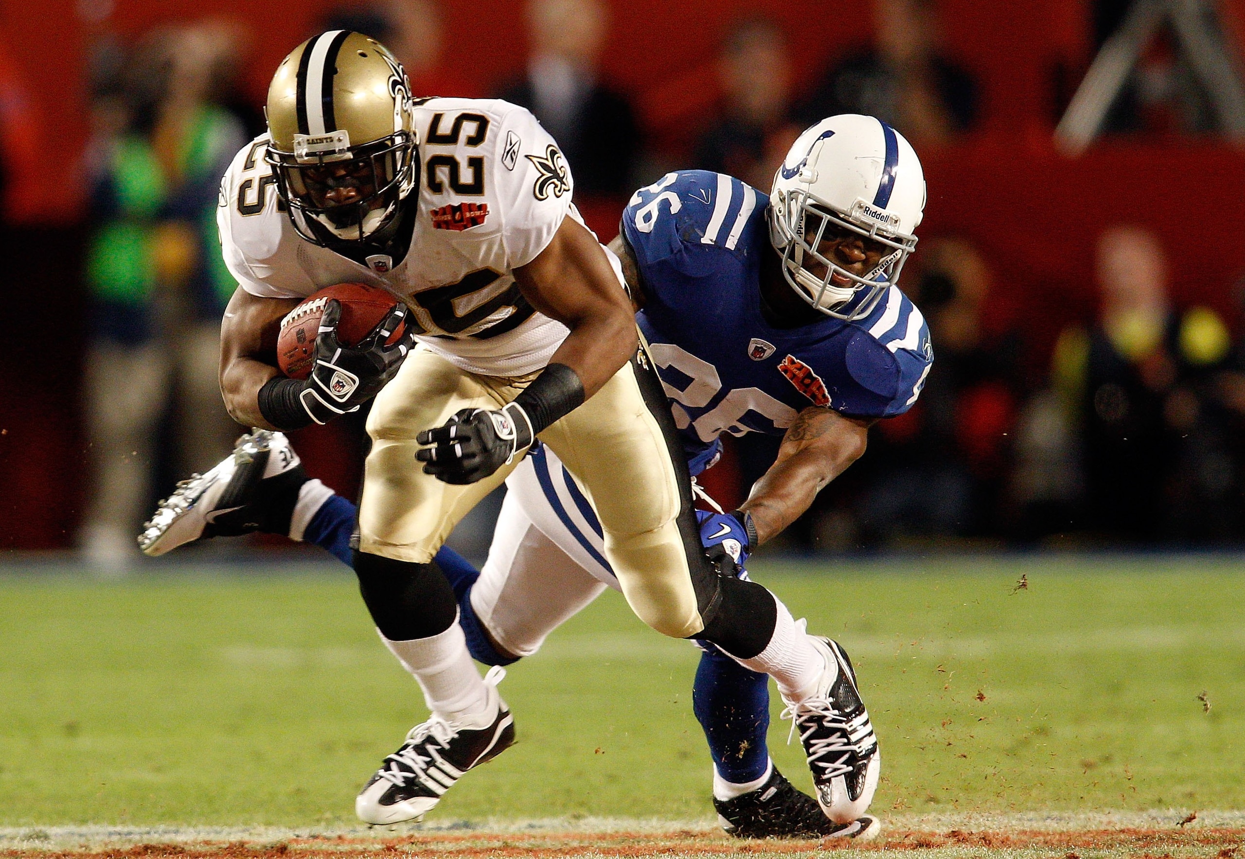 MIAMI GARDENS, FL - FEBRUARY 07:  Reggie Bush #25 of the New Orleans Saints gets a first down in front of Kelvin Hayden #26 of the Indianapolis Colts during Super Bowl XLIV on February 7, 2010 at Sun Life Stadium in Miami Gardens, Florida.  (Photo by Chri