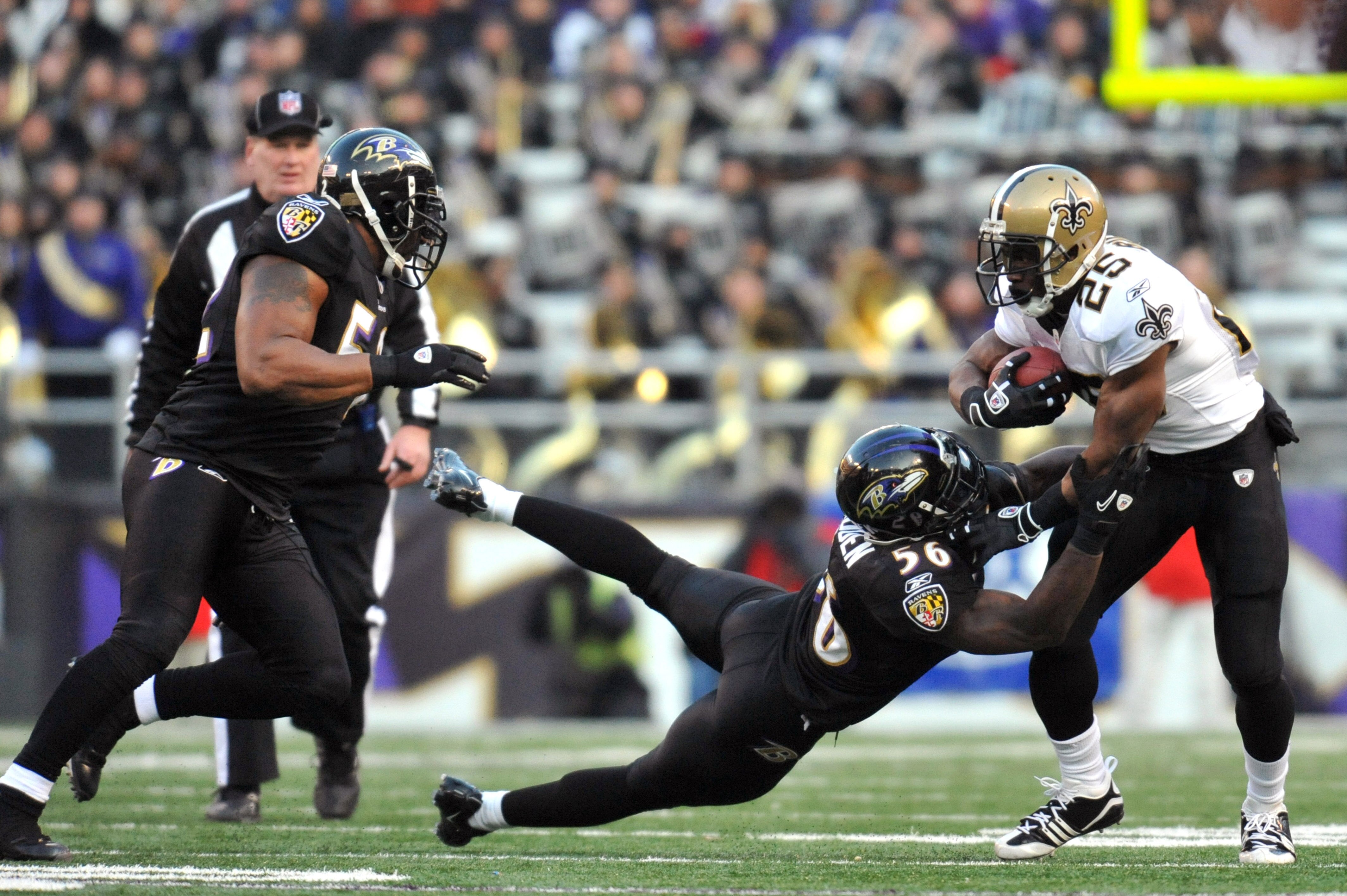 BALTIMORE, MD - DECEMBER 19:  Reggie Bush #25 of the New Orleans Saints is tackled by Tavares Gooden #56 of the Baltimore Ravens  at M&T Bank Stadium on December 19, 2010 in Baltimore, Maryland. The Ravens defeated the Saints 30-24. (Photo by Larry French