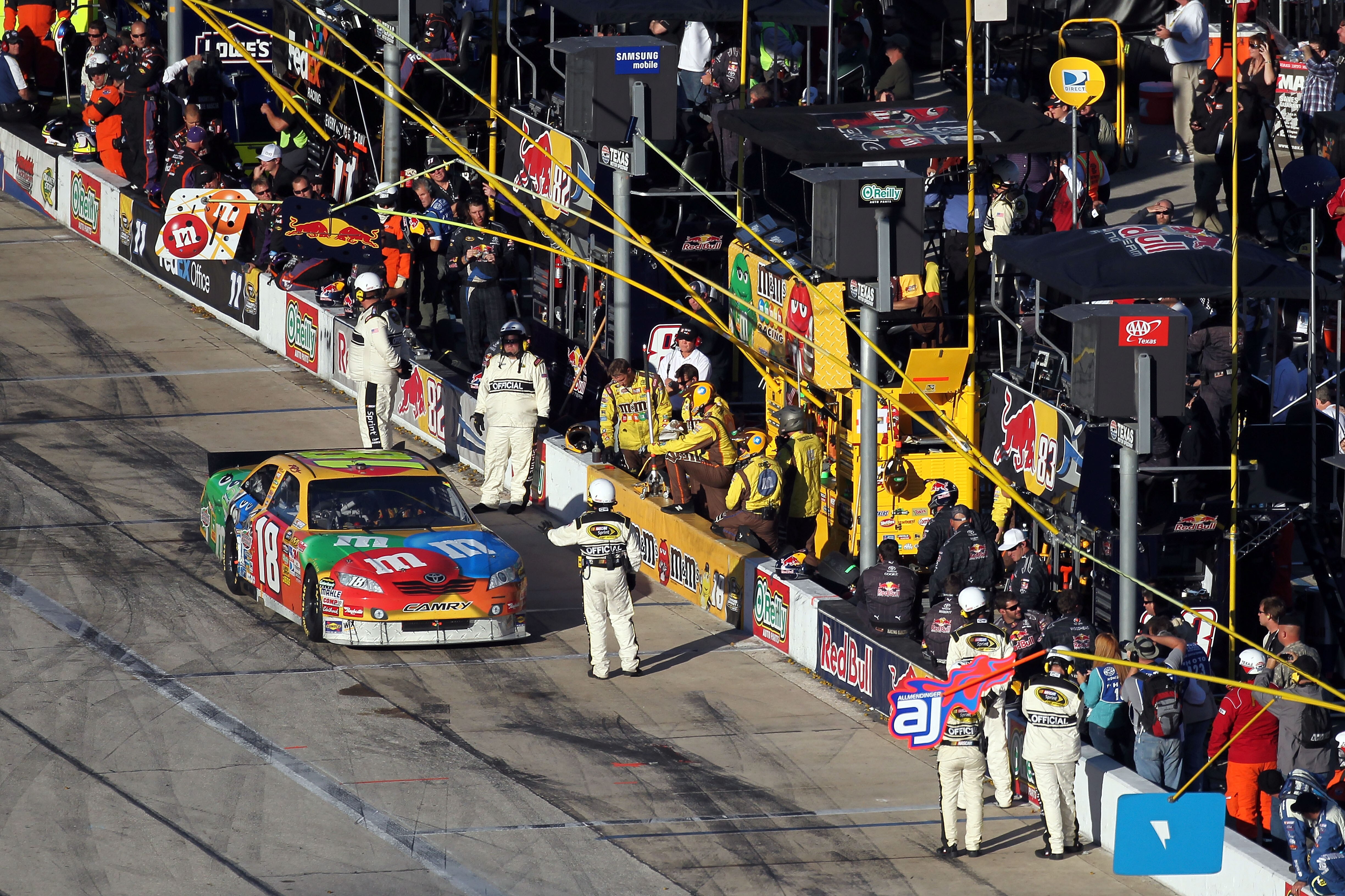 FORT WORTH, TX - NOVEMBER 07:  Kyle Busch, driver of the #18 M&M's Toyota, gets held by a NASCAR official on pit road after an incident in the NASCAR Sprint Cup Series AAA Texas 500 at Texas Motor Speedway on November 7, 2010 in Fort Worth, Texas.  (Photo