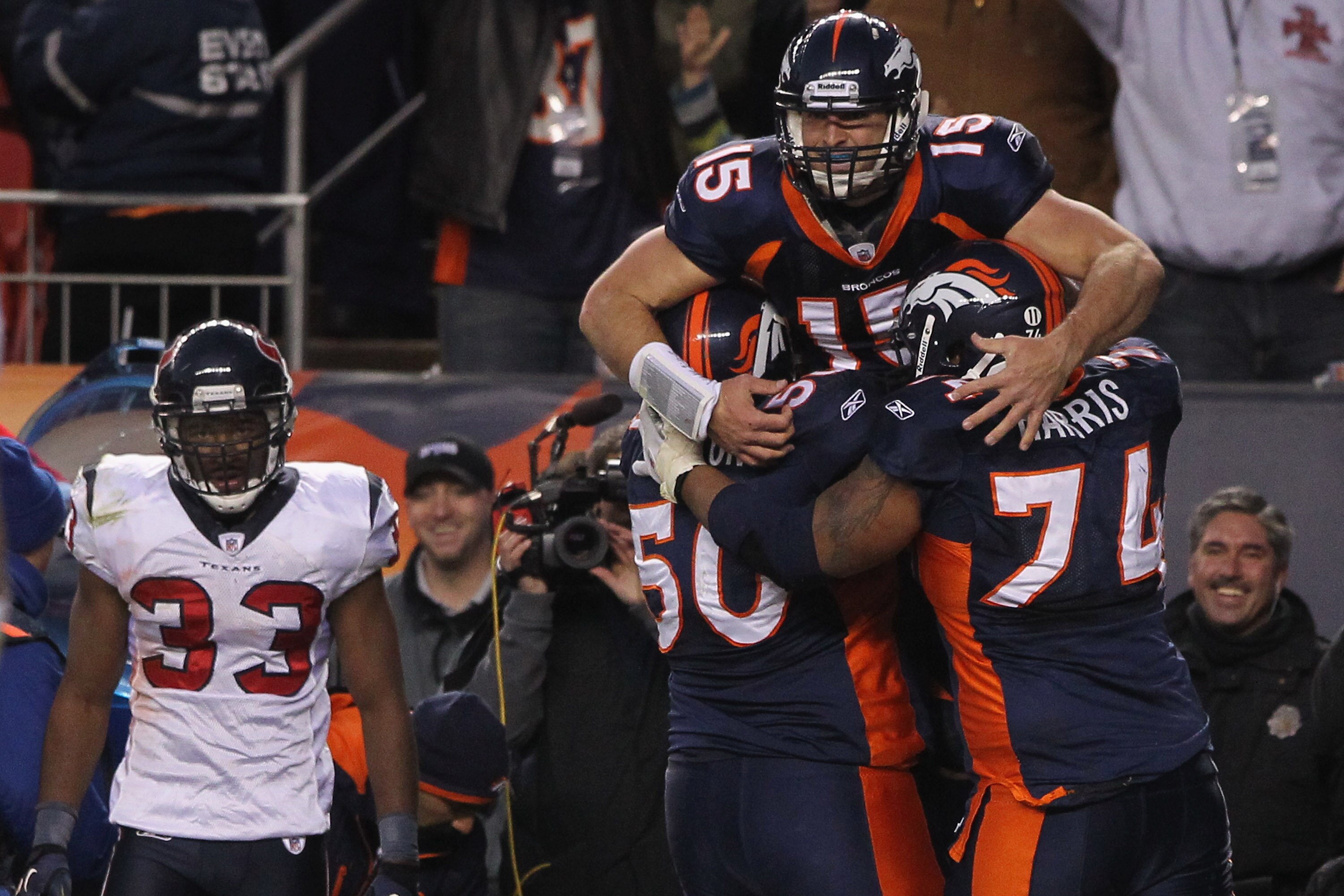 DENVER - DECEMBER 26:  Quarterback Tim Tebow #15 of the Denver Broncos jumps into the arms of his offensive linemen J.D. Walton #50 and Ryan Harris #74 after his game winning six yard bootleg touchdown run in the fourth quarter as free safety Troy Nolan #