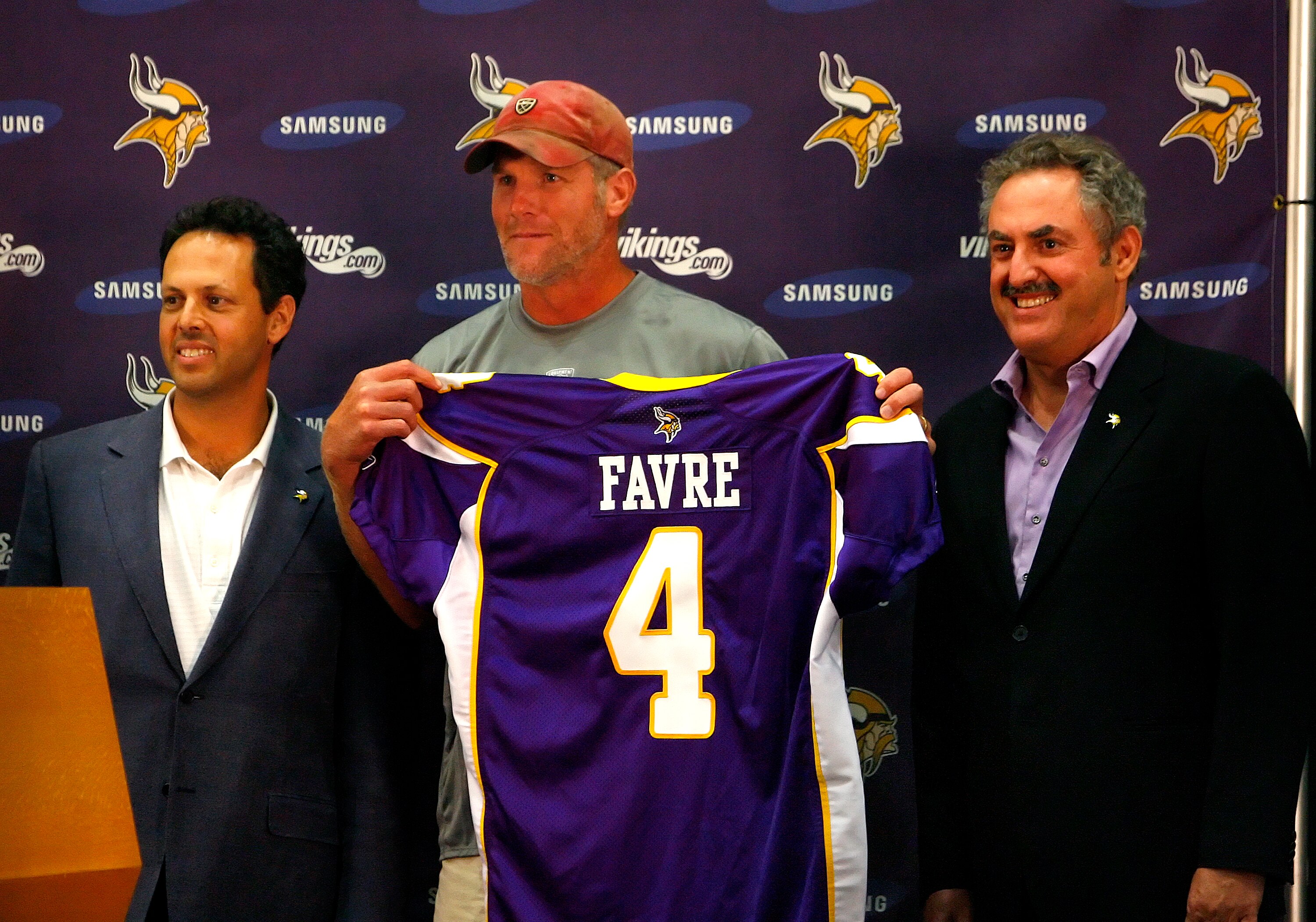 EDEN PRAIRIE, MN - AUGUST 18: Brett Favre (C), Mark Wilf (L) and Zygi Wilf show the media Favre's Minnesota Vikings jersey on August 18, 2009 at Winter Park in Eden Prairie, Minnesota. (Photo by Scott A. Schneider/Getty Images)