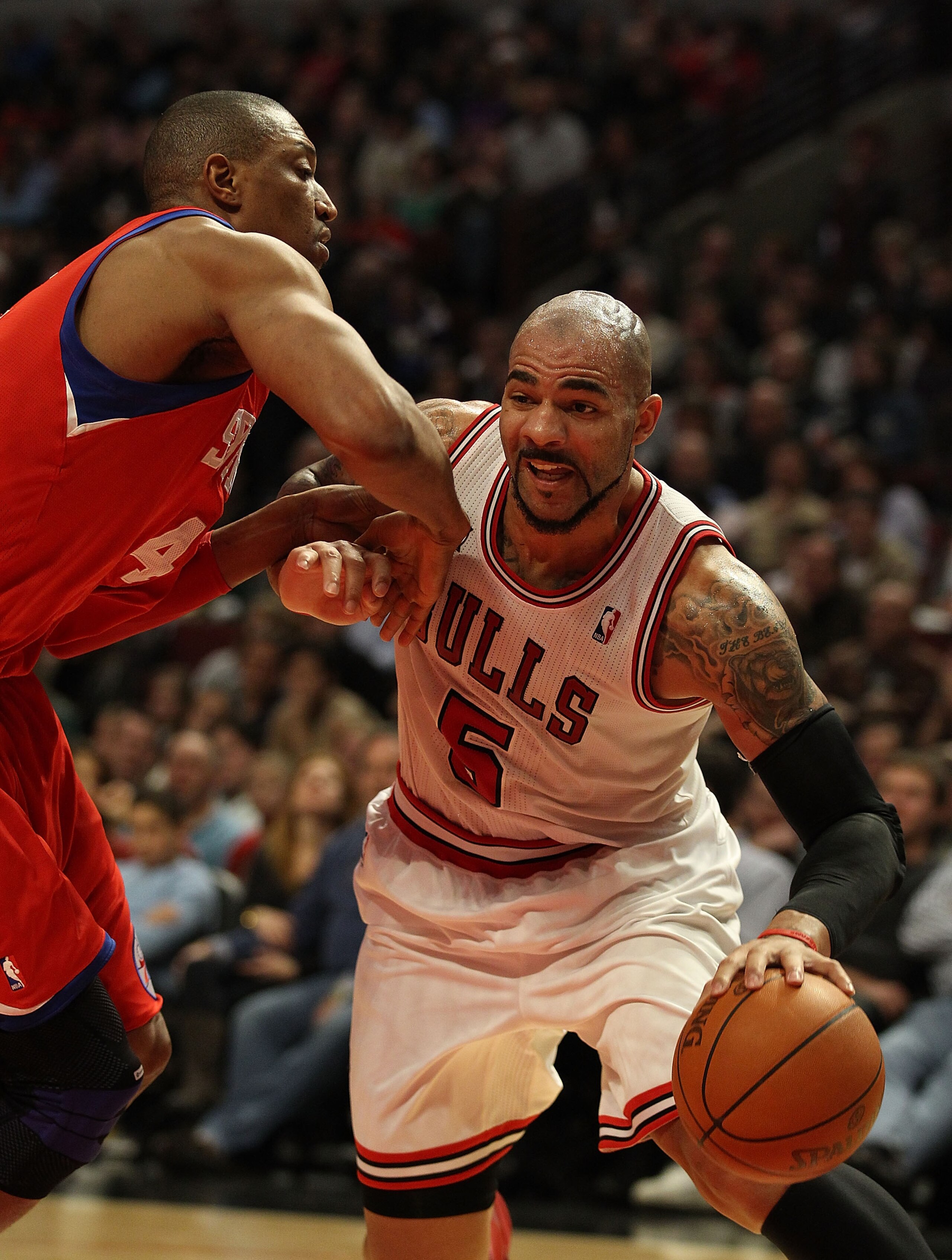 CHICAGO, IL - DECEMBER 21: Carlos Boozer #5 of the Chicago Bulls drives against Tony Battie #4 of the Philadelphia 76ers at the United Center on December 21, 2010 in Chicago, Illinois. The Bulls defeated the 76ers 121-76. NOTE TO USER: User expressly ackn CHICAGO, IL - DECEMBER 21: Carlos Boozer #5 of the Chicago Bulls drives against Tony Battie #4 of the Philadelphia 76ers at the United Center on December 21, 2010 in Chicago, Illinois. The Bulls defeated the 76ers 121-76. NOTE TO USER: User expressly ackn