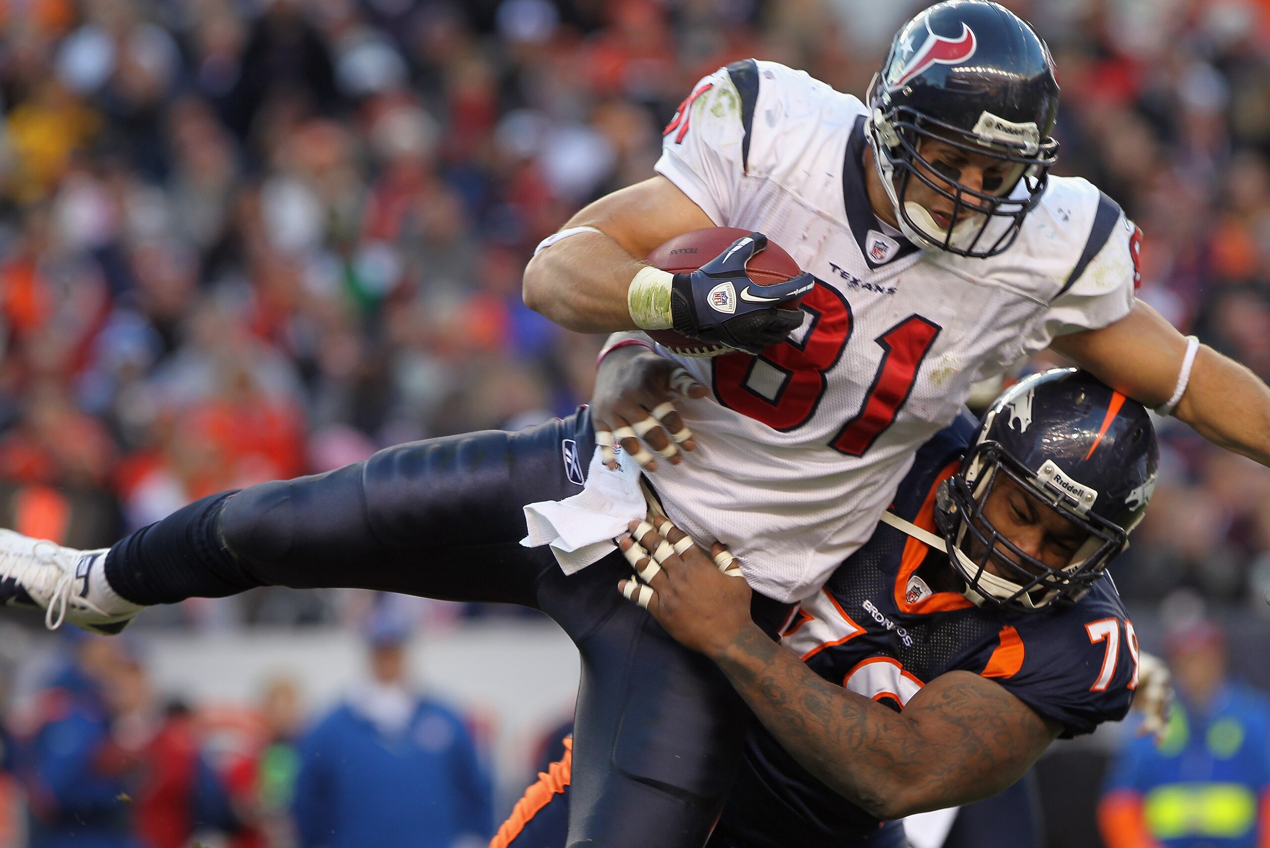 DENVER - DECEMBER 26: Wide receiver Owen Daniels #81 of the Houston Texas makes a reception and is tackled by defensive lineman Marcus Thomas #79 of the Denver Broncos at INVESCO Field at Mile High on December 26, 2010 in Denver, Colorado. The Broncos de DENVER - DECEMBER 26: Wide receiver Owen Daniels #81 of the Houston Texas makes a reception and is tackled by defensive lineman Marcus Thomas #79 of the Denver Broncos at INVESCO Field at Mile High on December 26, 2010 in Denver, Colorado. The Broncos de