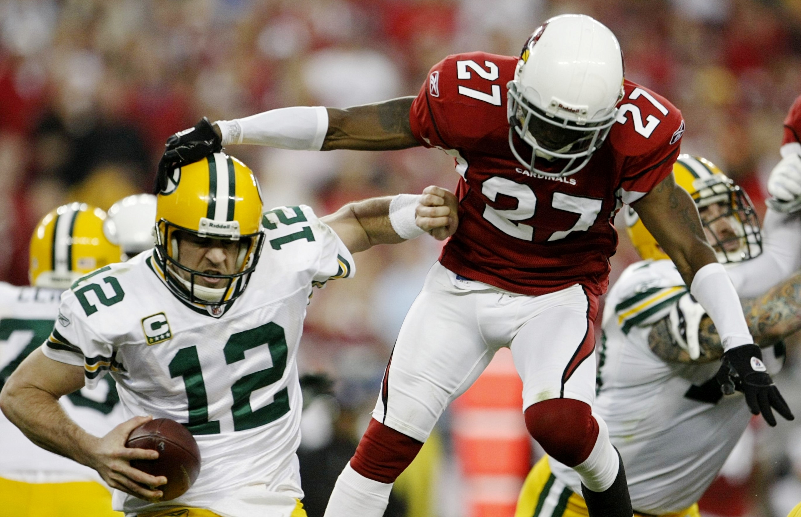 GLENDALE, AZ - JANUARY 10: Quarterback Aaron Rodgers #12 of the Green Bay Packers is hit by cornerback Michael Adams #27 of the Arizona Cardinals during the 2010 NFC wild-card playoff game at University of Phoenix Stadium on January 10, 2010 in Glendale, 