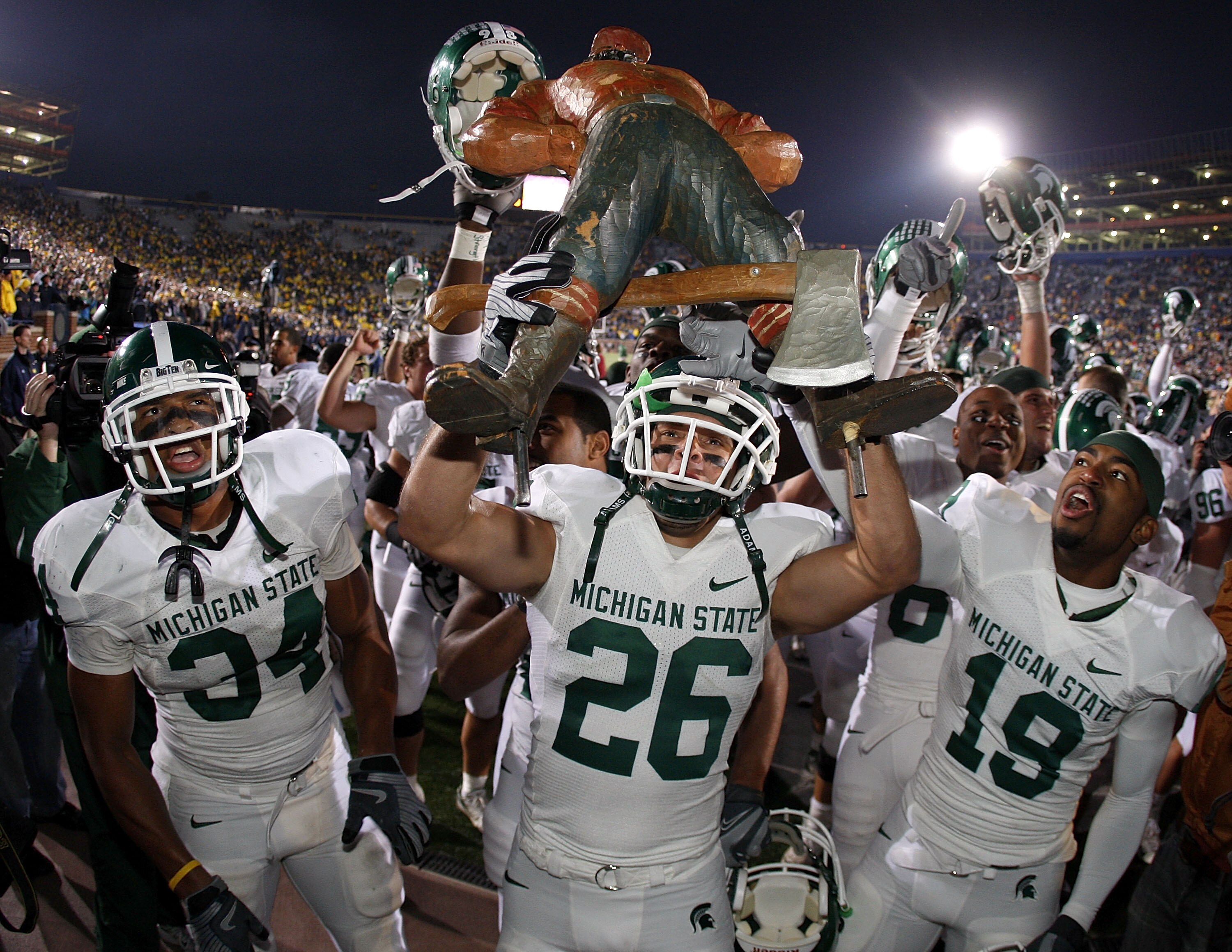 ANN ARBOR, MI - OCTOBER 25:  Jesse Johnson #26 of the Michigan State Spartans holds up the Paul Bunyan trophy between David Williams #19 and Brandon Denson #34 after beating the Michigan Wolverines 35-21 on October 25, 2008 at Michigan Stadium in Ann Arbo