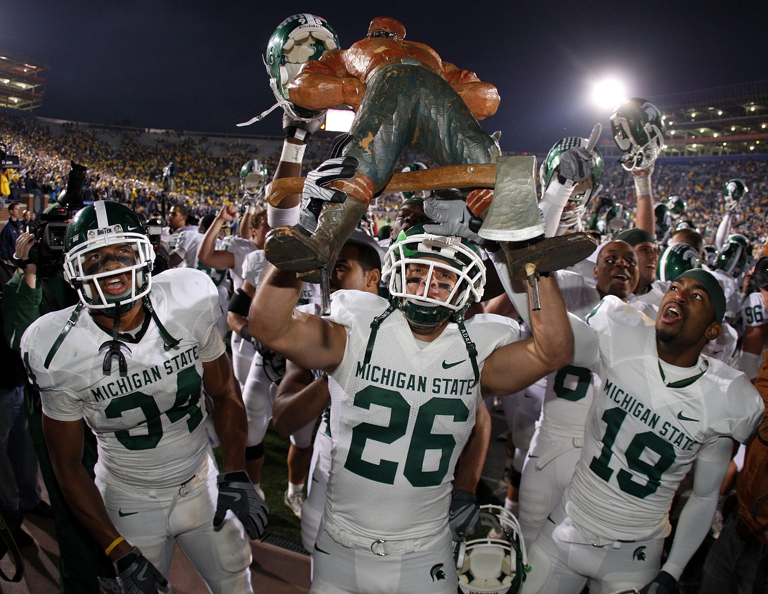ANN ARBOR, MI - OCTOBER 25:  Jesse Johnson #26 of the Michigan State Spartans holds up the Paul Bunyan trophy between David Williams #19 and Brandon Denson #34 after beating the Michigan Wolverines 35-21 on October 25, 2008 at Michigan Stadium in Ann Arbo