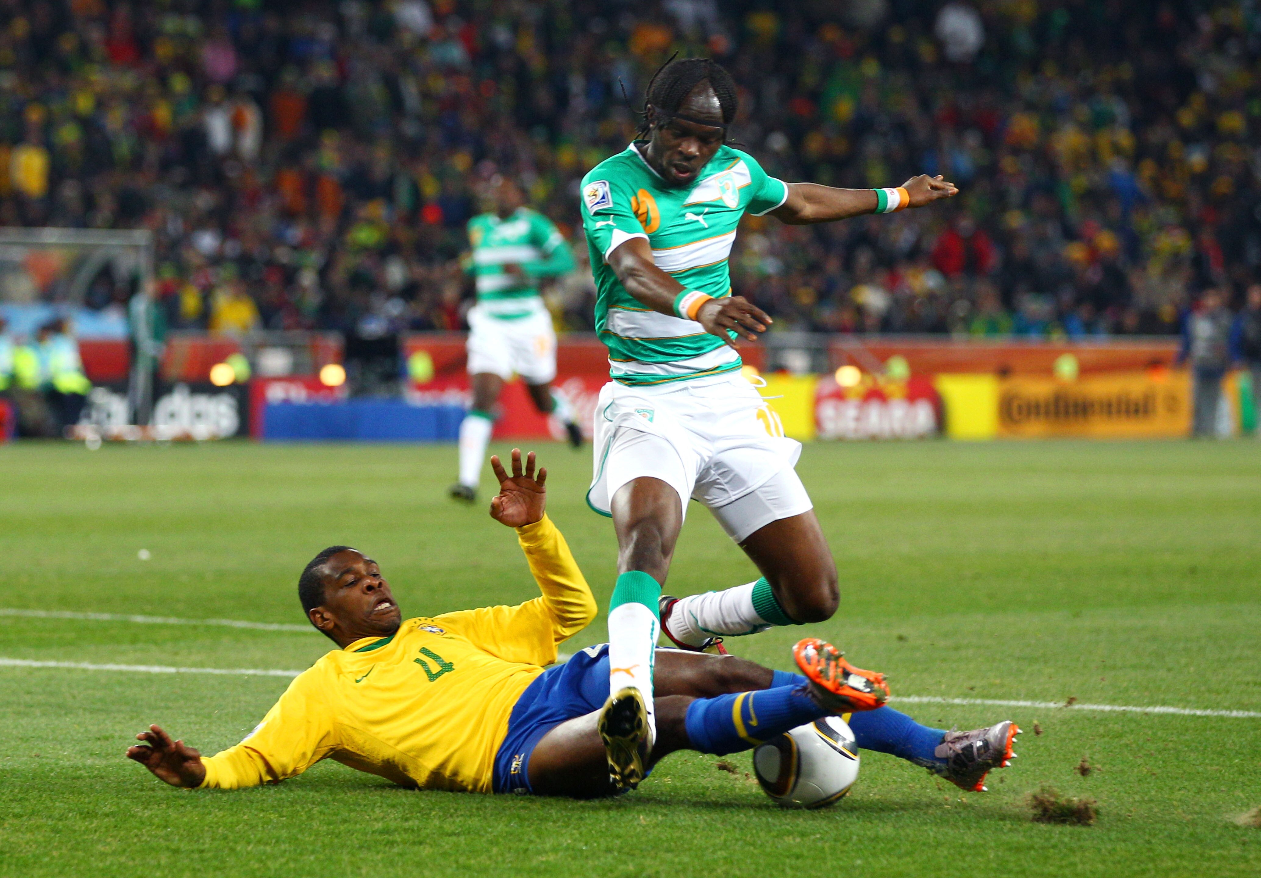 JOHANNESBURG, SOUTH AFRICA - JUNE 20:  Juan of Brazil tackles Gervinho of the Ivory Coast during the 2010 FIFA World Cup South Africa Group G match between Brazil and Ivory Coast at Soccer City Stadium on June 20, 2010 in Johannesburg, South Africa.  (Pho