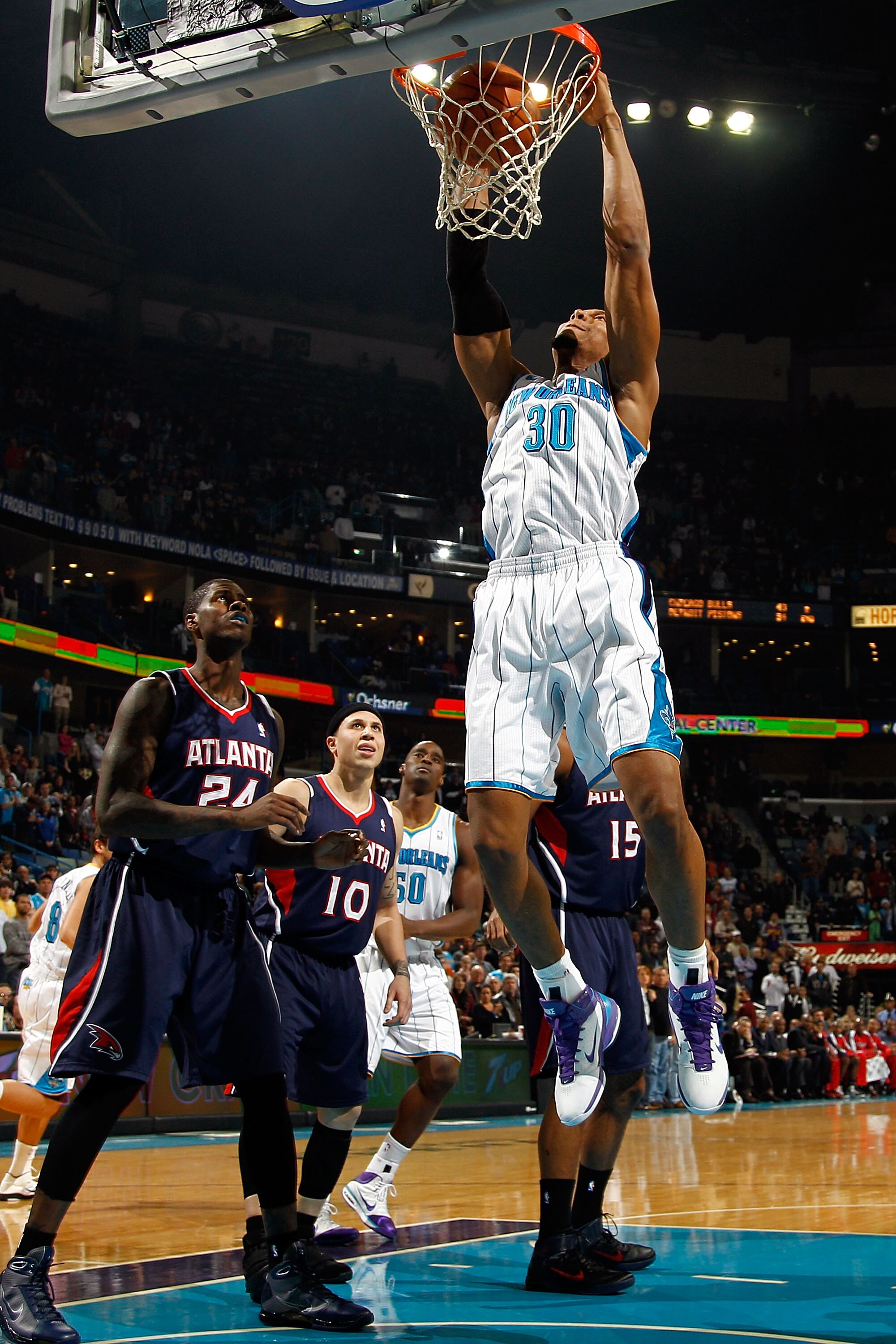 NEW ORLEANS, LA - DECEMBER 26:  David West #30 of the New Orleans Hornets dunks the ball over Marvin Williams #24 of the Atlanta Hawks at the New Orleans Arena on December 26, 2010 in New Orleans, Louisiana.  NOTE TO USER: User expressly acknowledges and