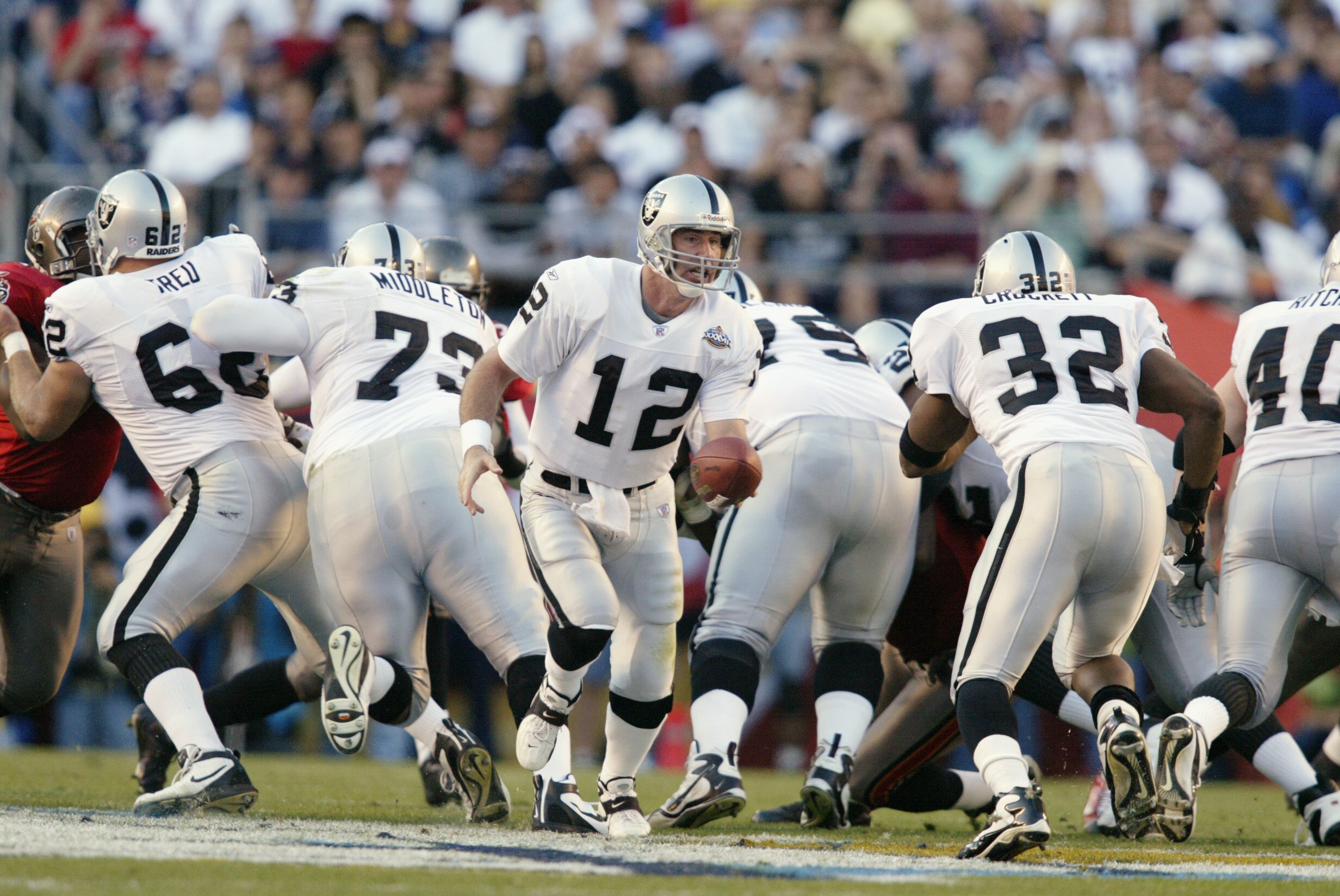 SAN DIEGO - JANUARY 26:  Quarterback Rich Gannon #12 of the Oakland Raiders hands the ball to his teammate fullback Zack Crockett #32 during Super Bowl XXXVII against the Tampa Bay Buccaneers at Qualcomm Stadium on January 26, 2003 in San Diego, Californi