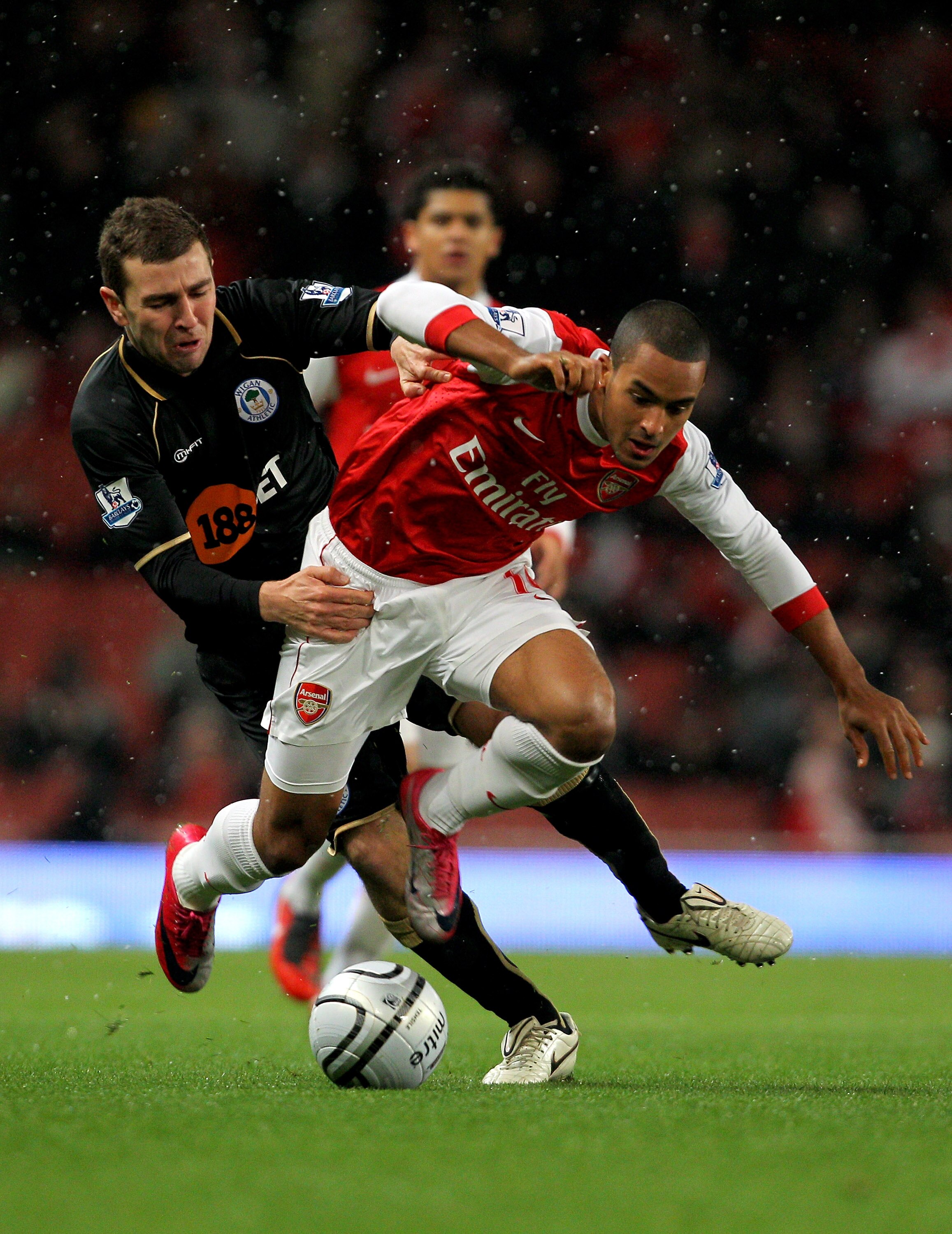 LONDON, ENGLAND - NOVEMBER 30:  Theo Walcott (L) of Arsenal tangles with James McCarthur of Wigan during the Carling Cup quarter final match between Arsenal and Wigan Athletic at the Emirates Stadium on November 30, 2010 in London, England.  (Photo by Cli