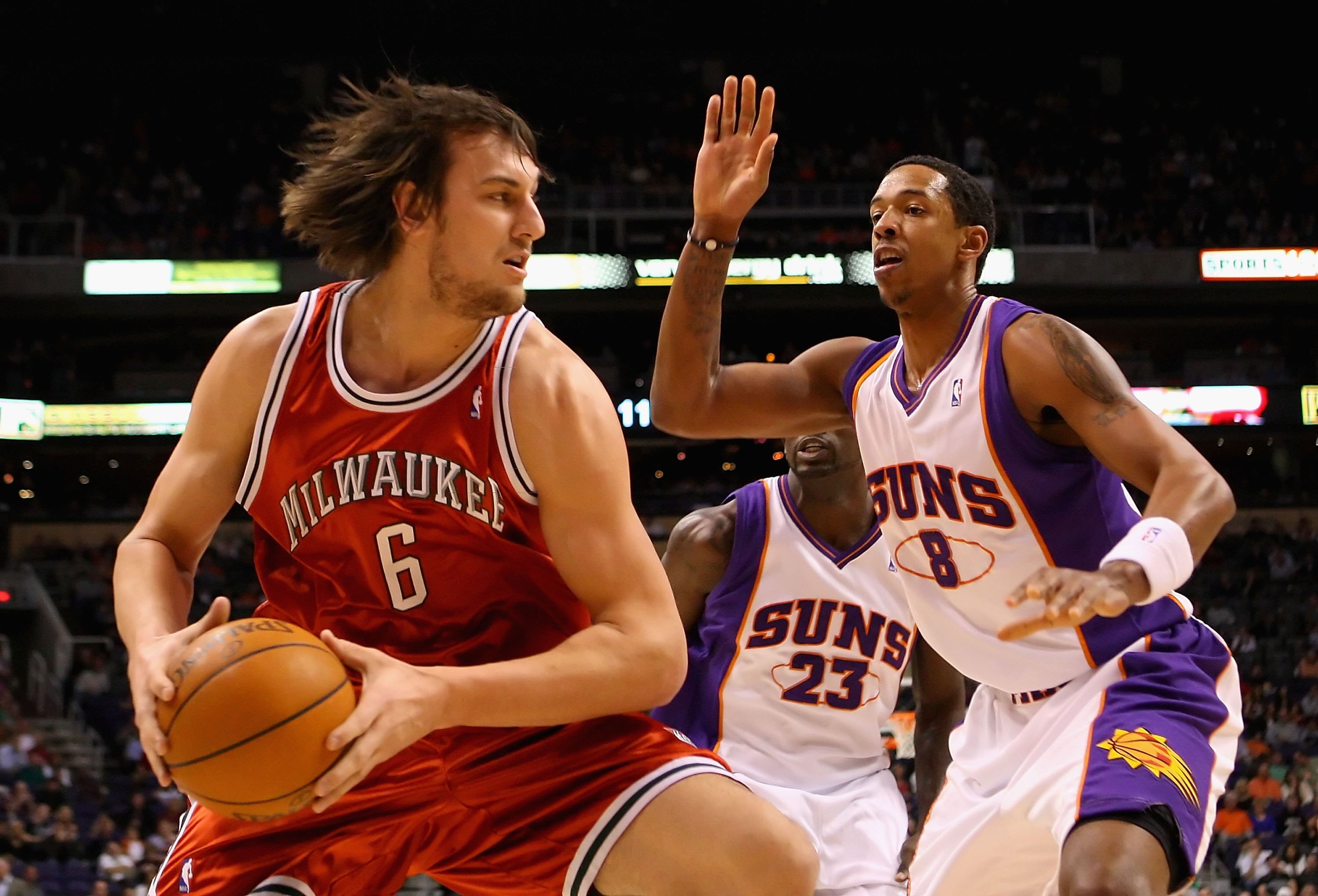 PHOENIX - JANUARY 11:  Andrew Bogut #6 of the Milwaukee Bucks handles the ball under pressure from Channing Frye #8 of the Phoenix Suns during the NBA game at US Airways Center on January 11, 2010 in Phoenix, Arizona. The Suns defeated the Rockets 118-110