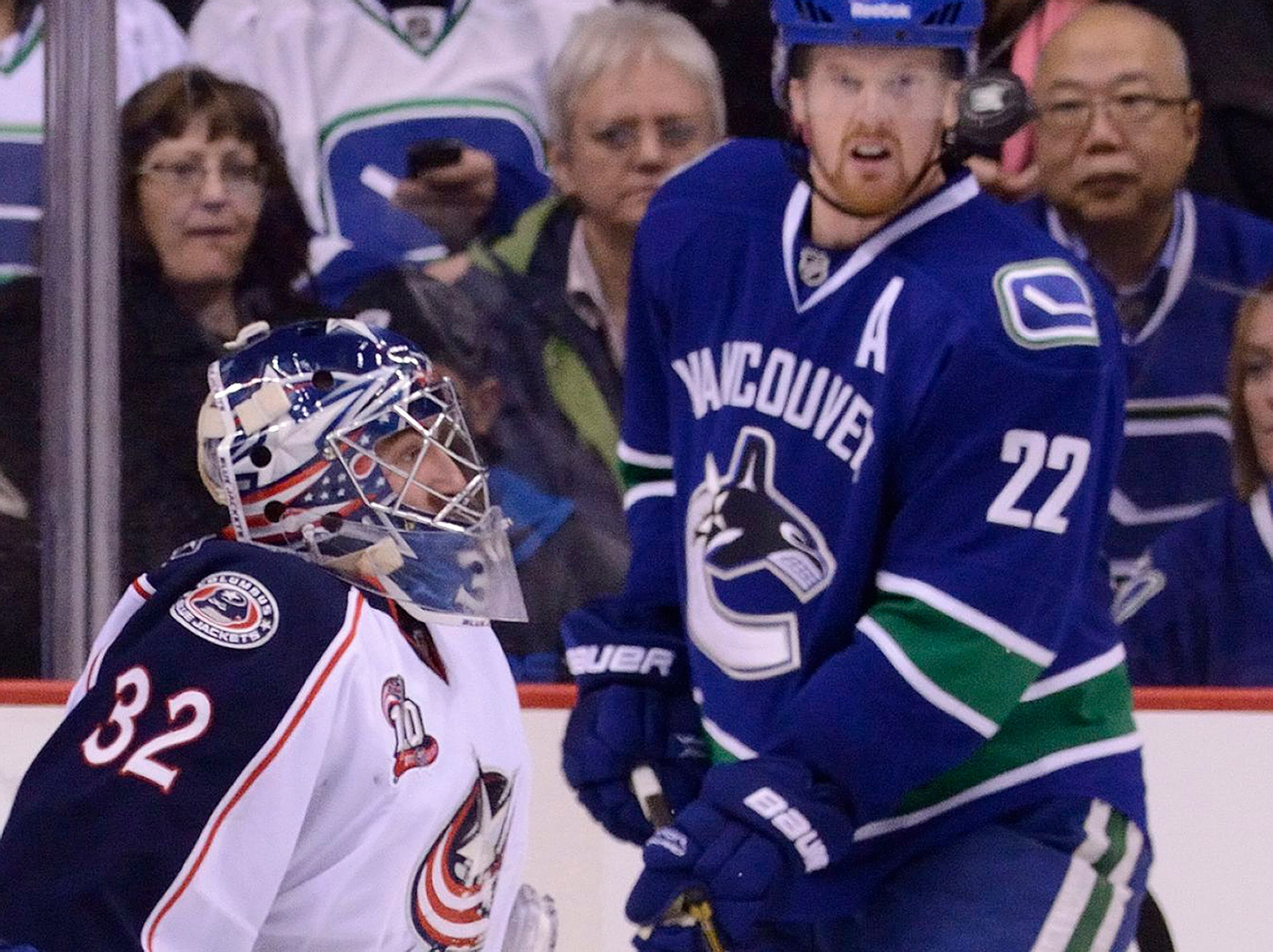 VANCOUVER, CANADA - DECEMBER 15: Goalie Mathieu Garon #32 of the Columbus Blue Jackets and Daniel Sedin #22 of the Vancouver Canucks keep a close eye on an airborne puck during the third period in NHL action on December 15, 2010 at Rogers Arena in Vancouv