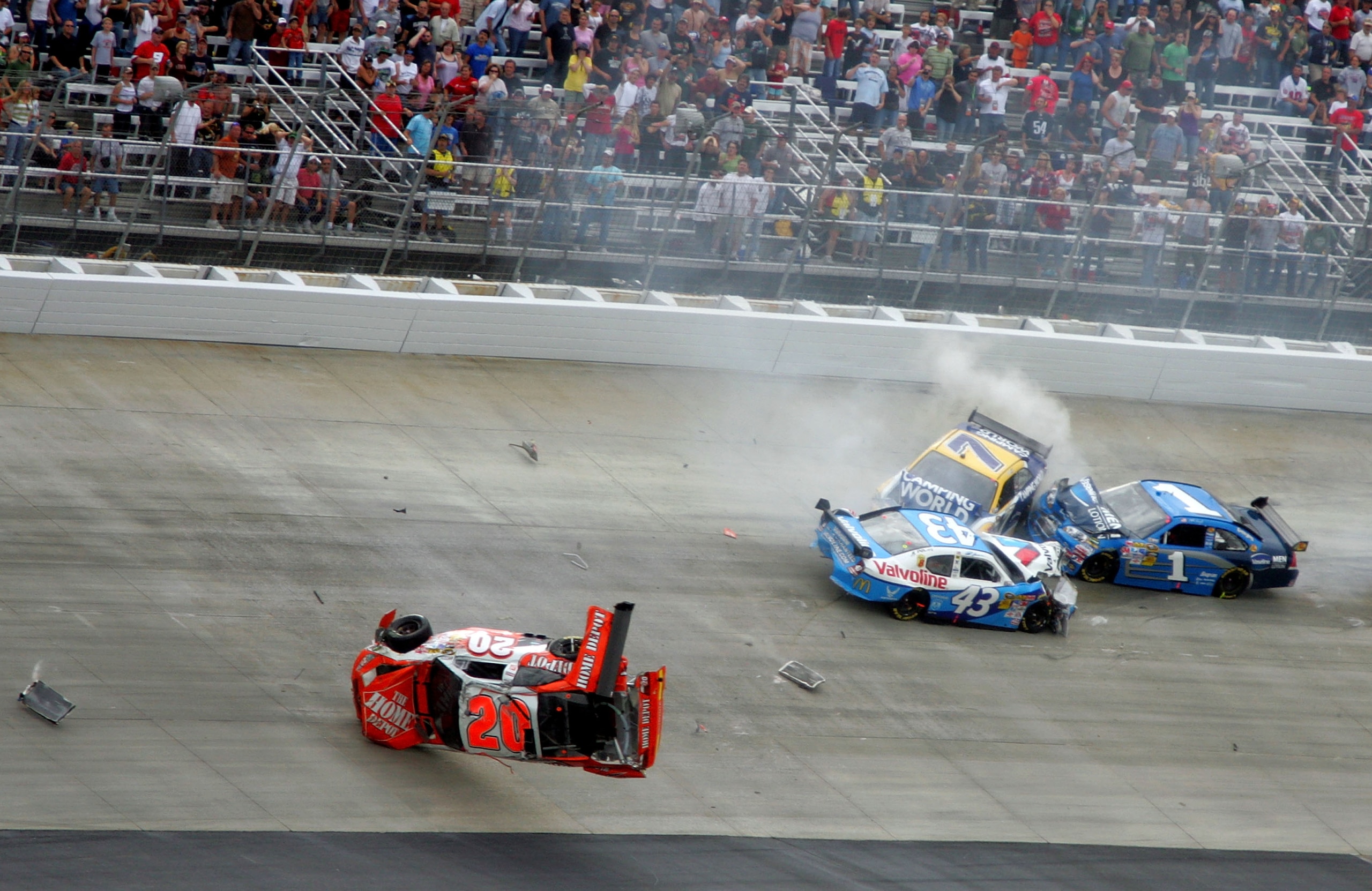 DOVER, DE - SEPTEMBER 27:  (L-R) Joey Logano, driver of the #20 Home Depot Toyota, flips his car after he was involved in a wreck with Reed Sorenson, driver of the #43 Valvoline Dodge, Robby Gordon, driver of the #7 Camping World Toyota and Martin Truex J