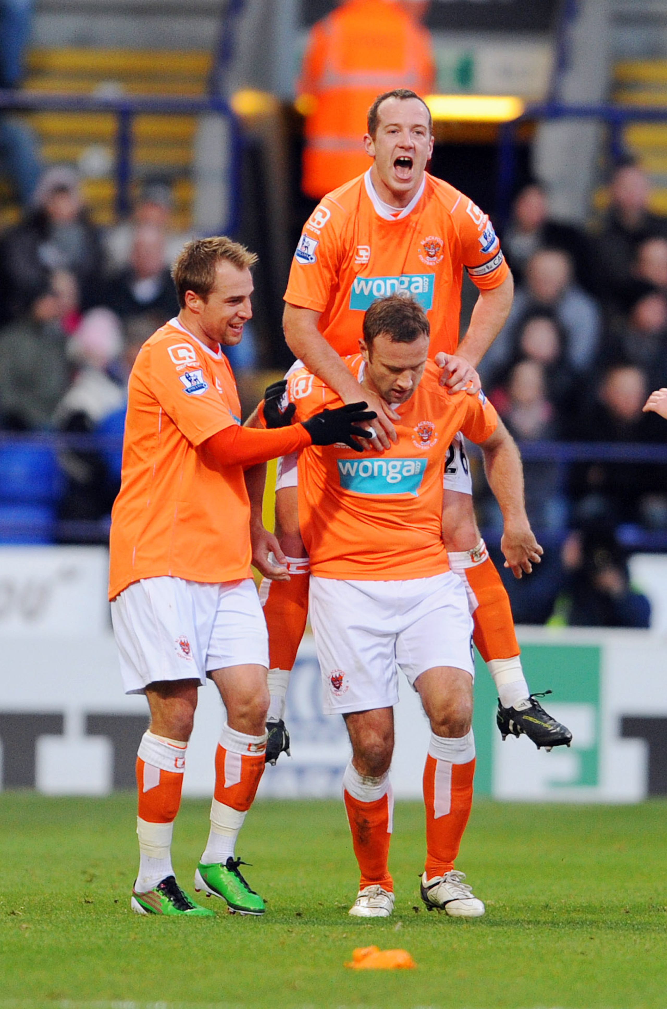 BOLTON, UNITED KINGDOM - NOVEMBER 27: Ian Evatt (ground right) of Blackpool celebrates with team-mate Charlie Adam (Top) after scoring his sides first goal during the Barclays Premier League match between Bolton Wanderers and Blackpool at the Reebok Stadi