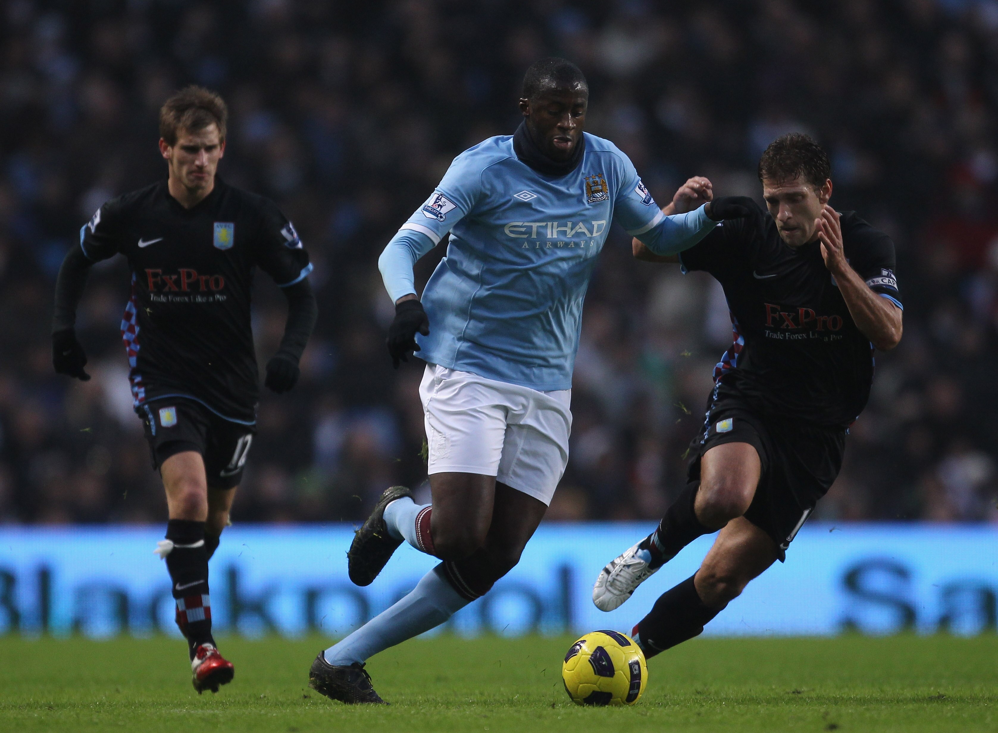 MANCHESTER, ENGLAND - DECEMBER 28:  Yaya Toure of Manchester City holds off a challenge from Stiliyan Petrov of Aston Villa during the Barclays Premier League match between Manchester City and Aston Villa at the City of Manchester Stadium on December 28,