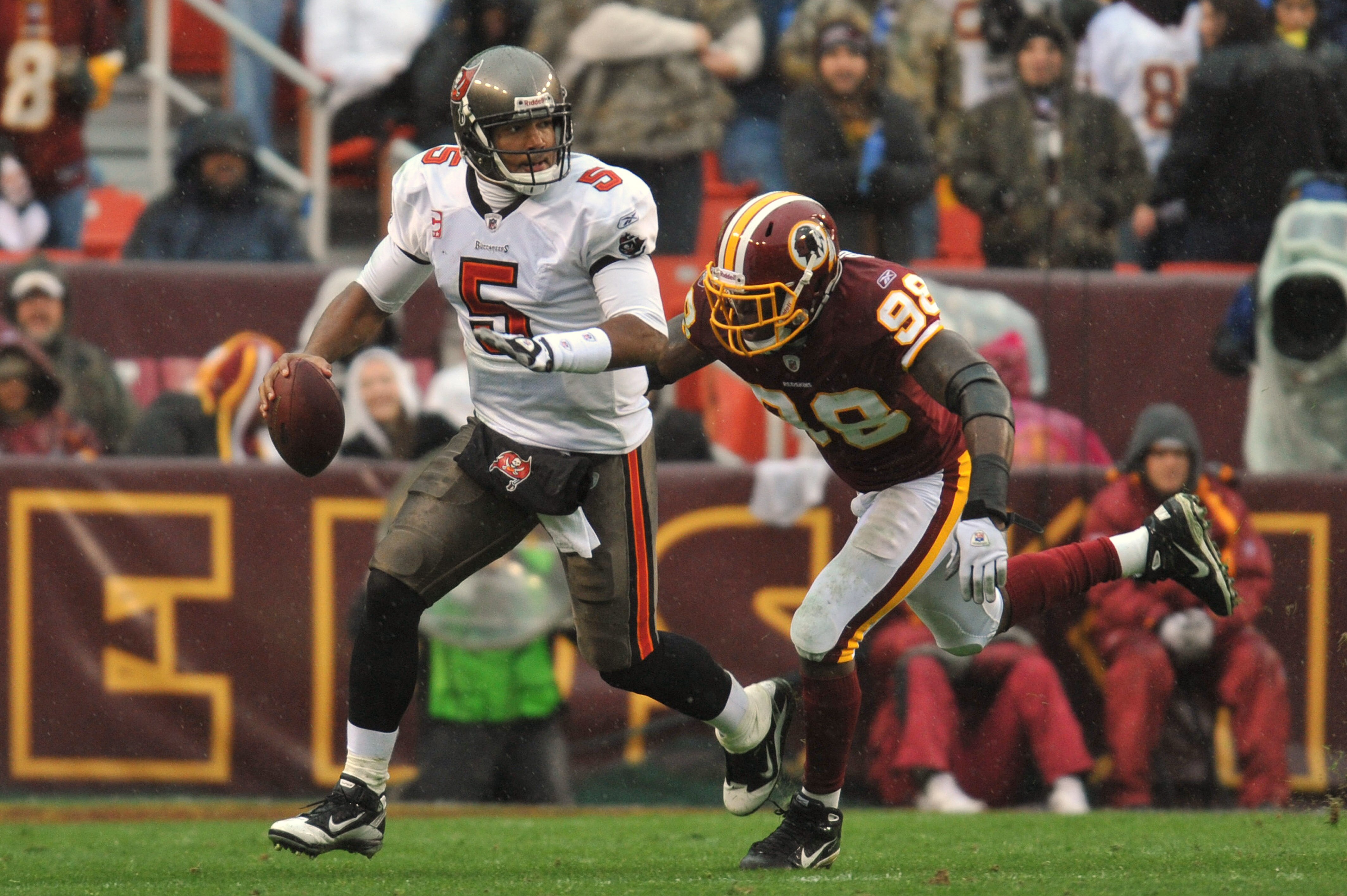 LANDOVER, MD - DECEMBER 12:  Josh Freeman #5 of the Tampa Bay Buccaneers is chased by Brian Orakpo #98 of the Washington Redskins at FedExField on December 12, 2010 in Landover, Maryland. The Redskins led the Buccaneers at the half 10-3 00-00. (Photo by L