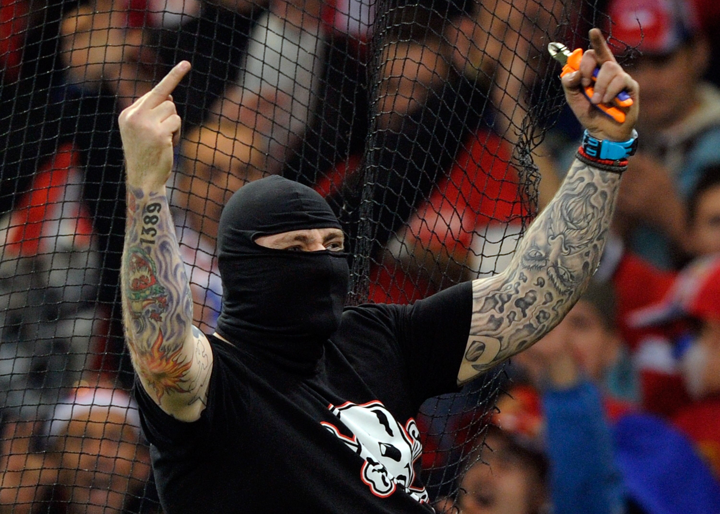 GENOA, ITALY - OCTOBER 12:  Balaclava clad Serbian fan Ivan Bogdanov gestures towards riot police during the UEFA Euro 2012 qualifying match between Italy and Serbia at Luigi Ferraris Stadium on October 12, 2010 in Genoa, Italy.  (Photo by Claudio Villa/G