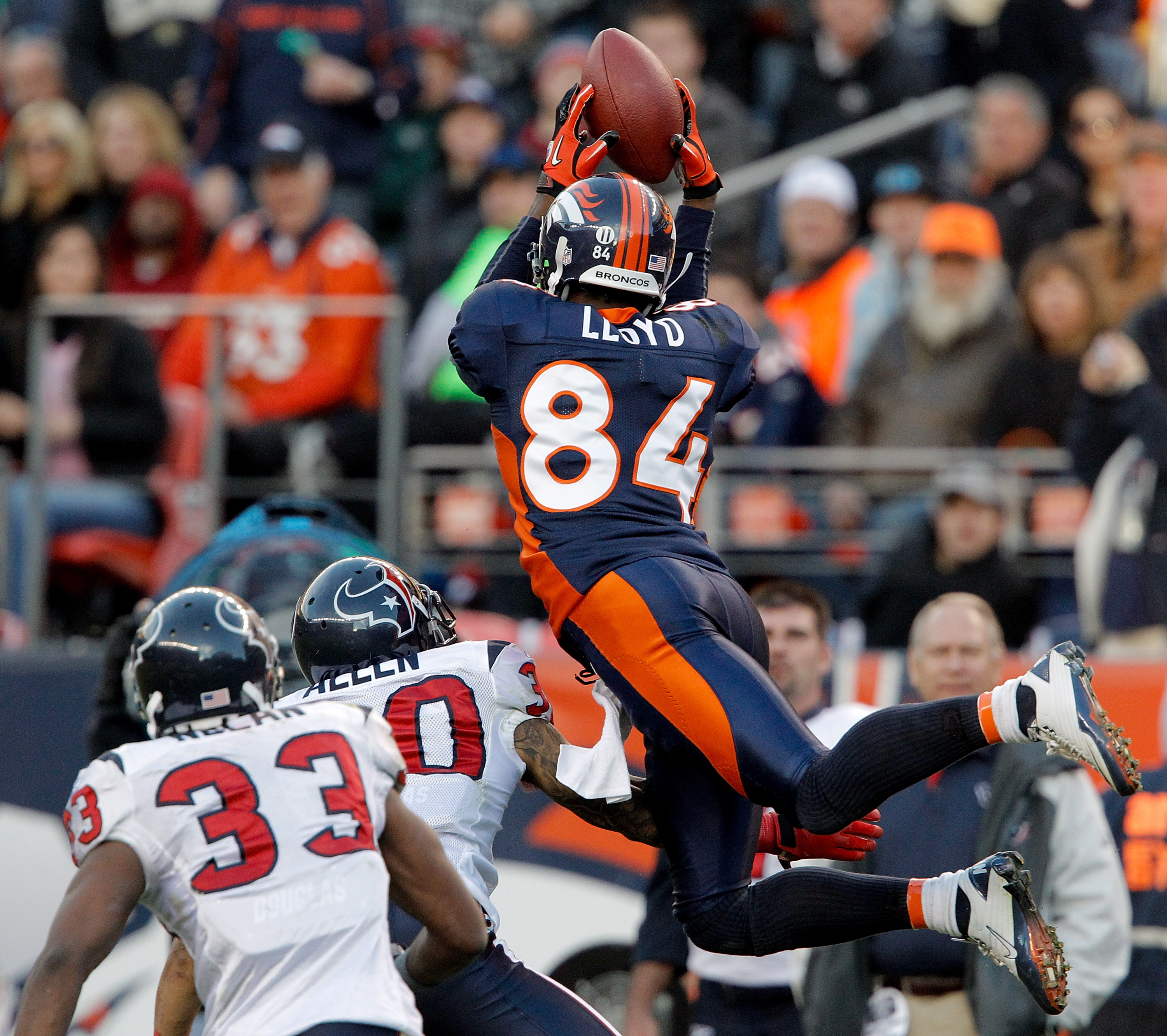 DENVER - DECEMBER 26:  Wide receiver Brandon Lloyd #84 of the Denver Broncos makes a leaping catch for a 41-yard reception against corner back Jason Allen #30 and safety Troy Nolan #33 of the Houston Texans during the third quarter at INVESCO Field at Mil